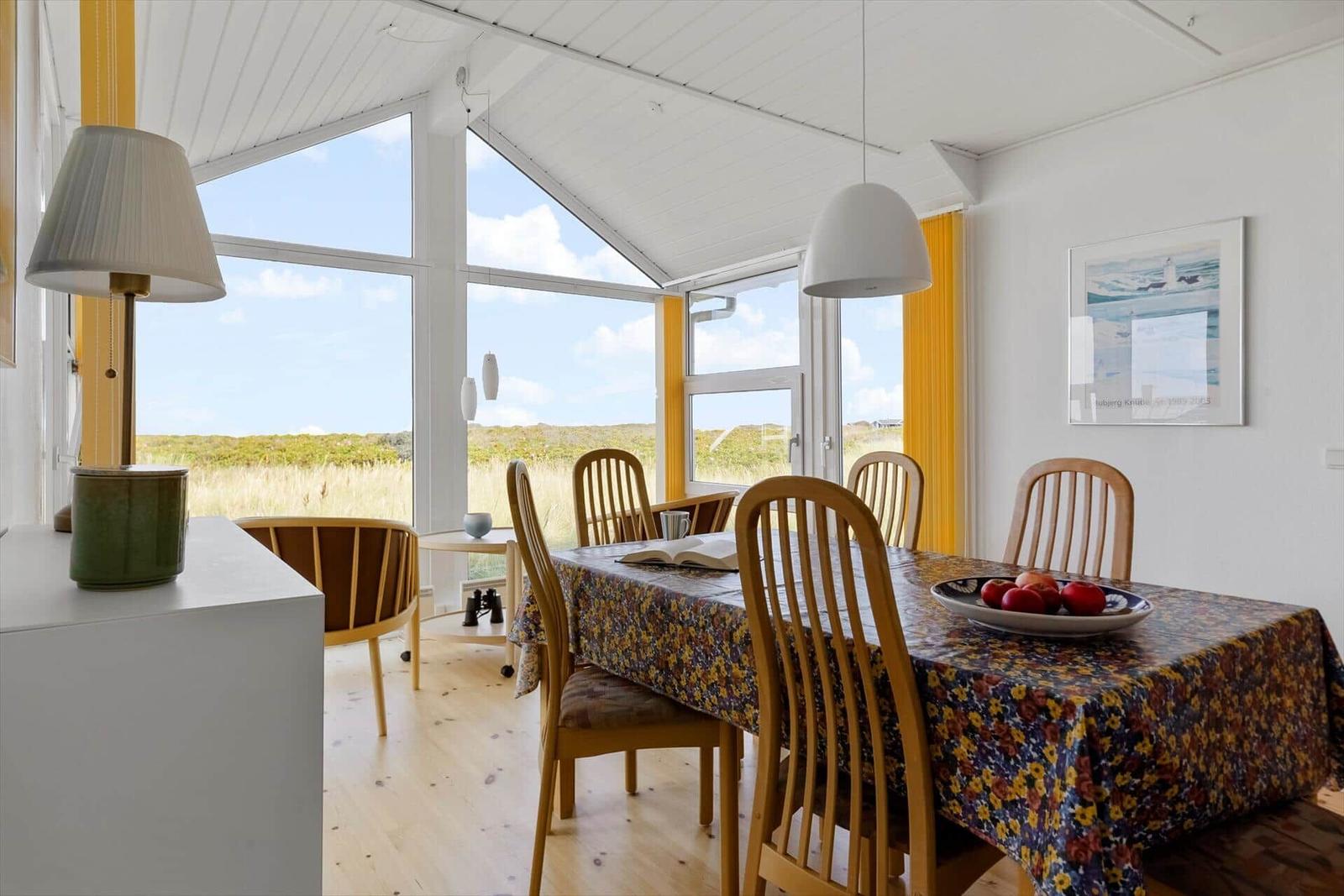 Esszimmer mit Tisch, Stühlen und Blick auf Grasland