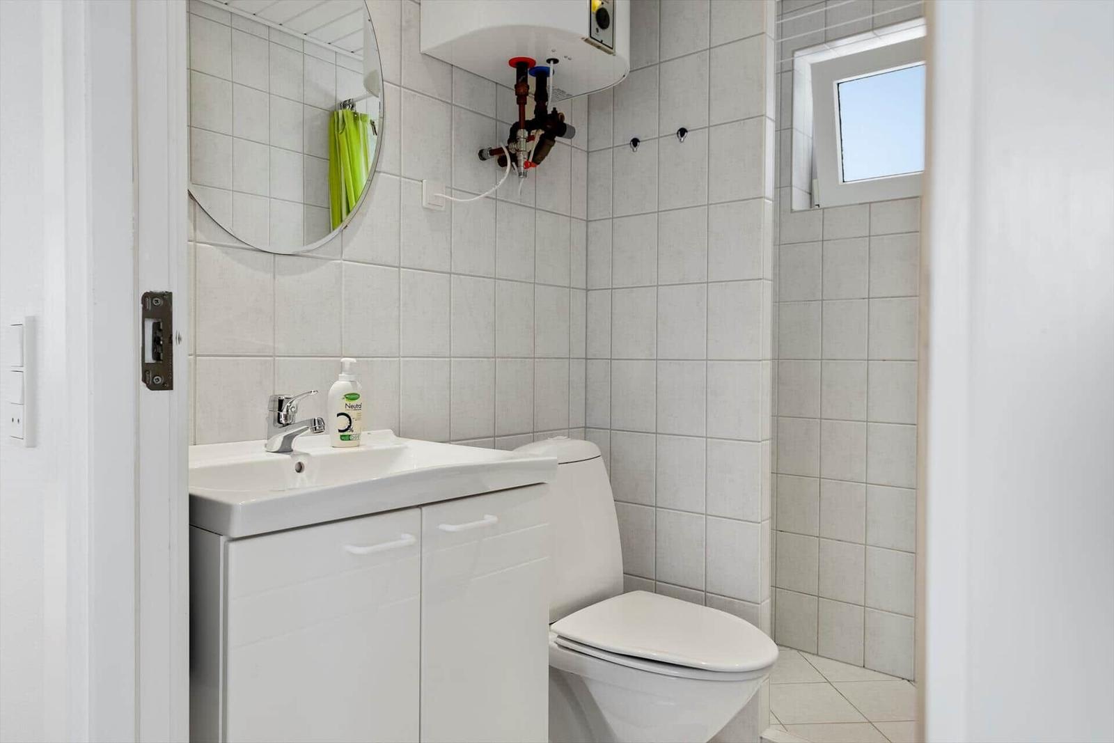 Badezimmer mit Waschbecken, Toilette und Spiegel an der Wand.
