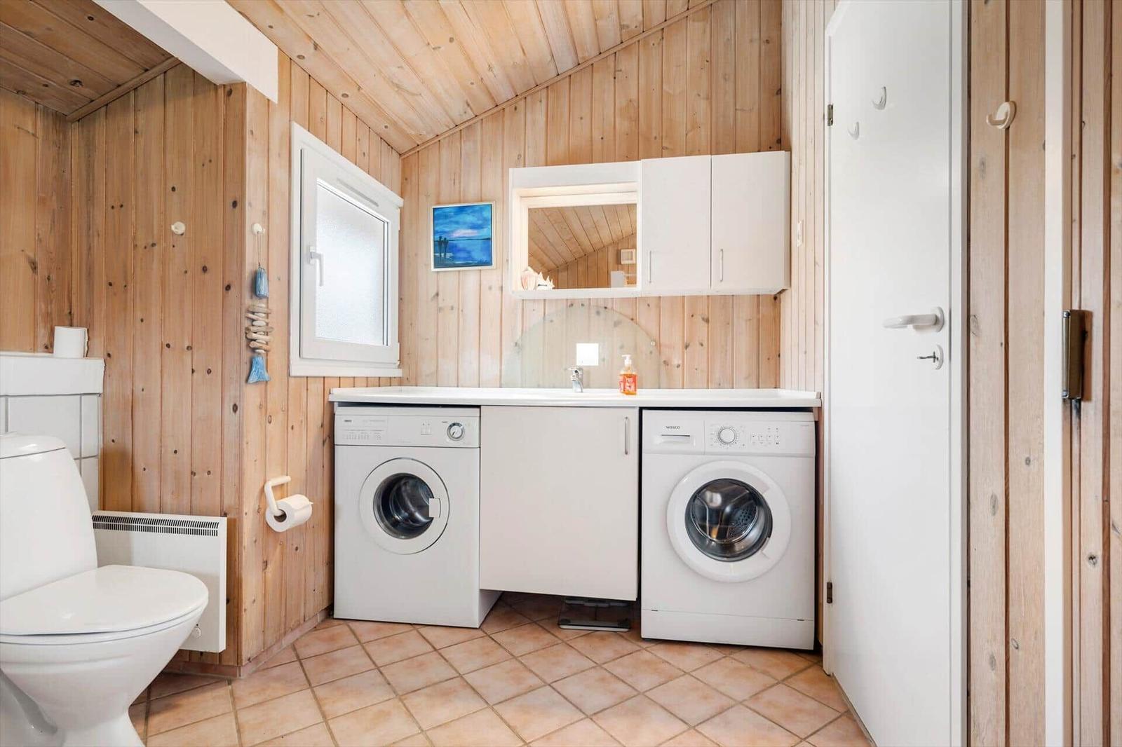 Wohnung mit Waschmaschine, Trockner und Toilette in Holzhaus.