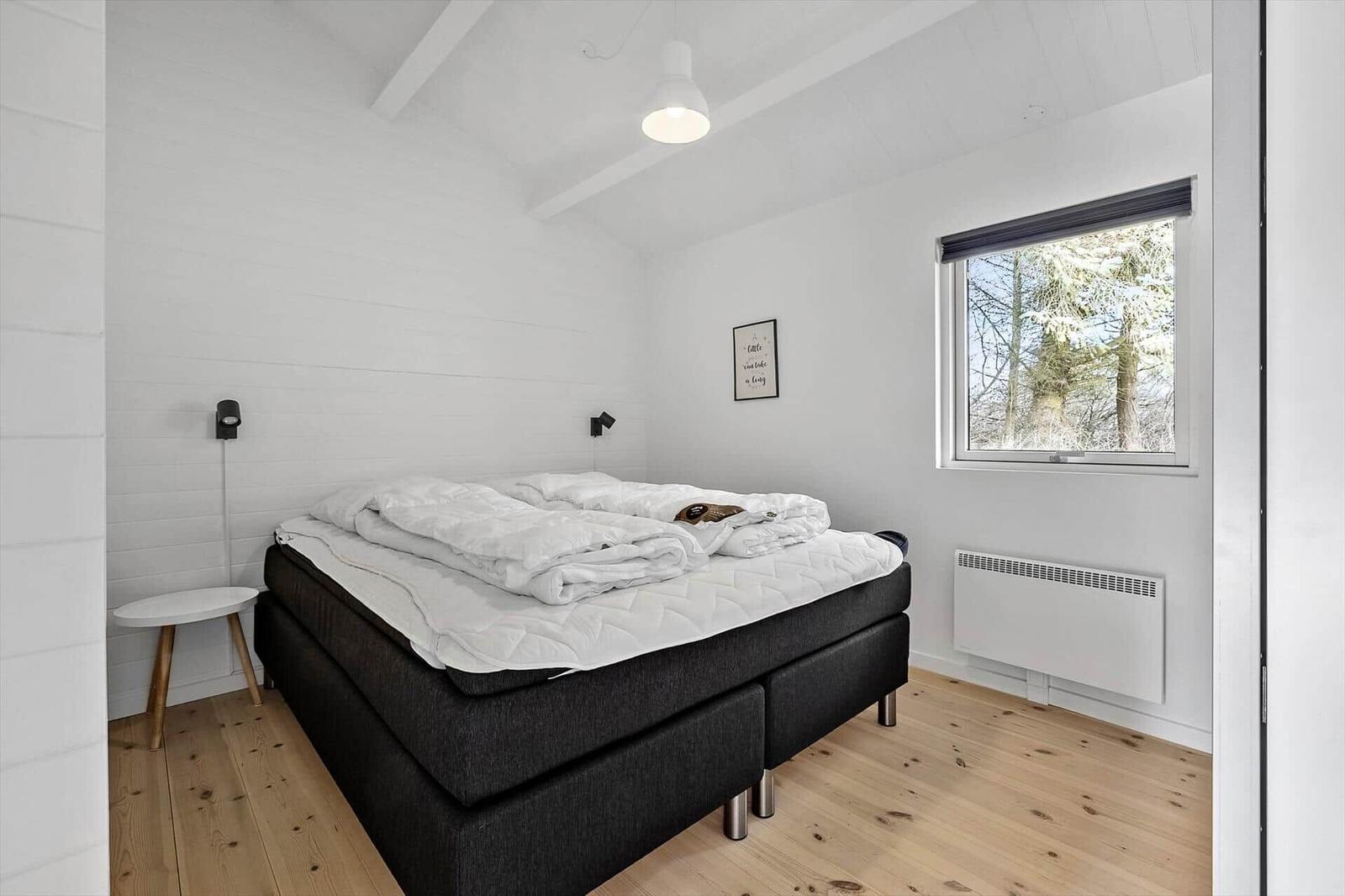 Schlafzimmer mit Bett, Fenster und Holzboden