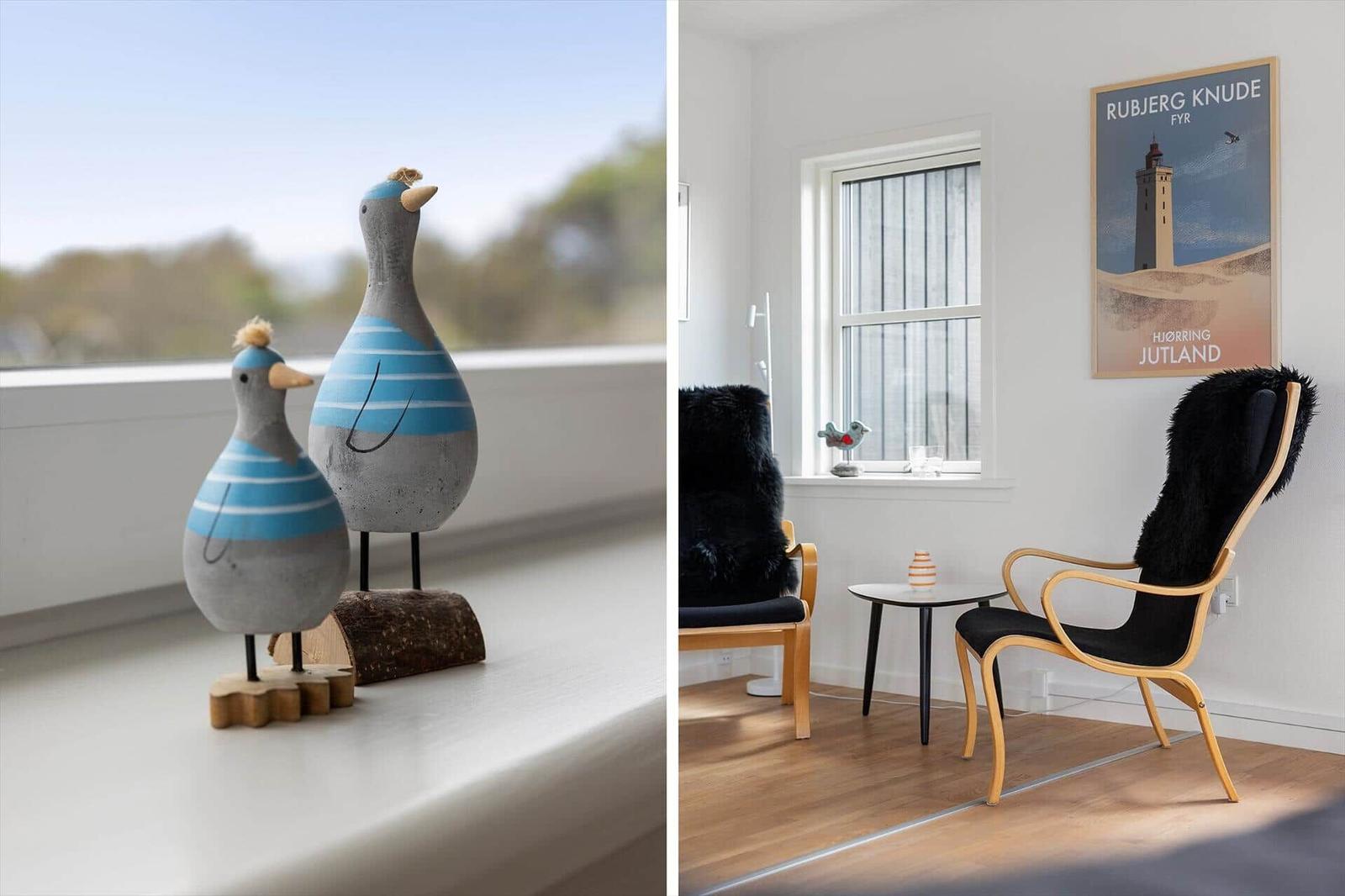 Two wooden bird decorations on a windowsill. A room with two chairs and a poster.