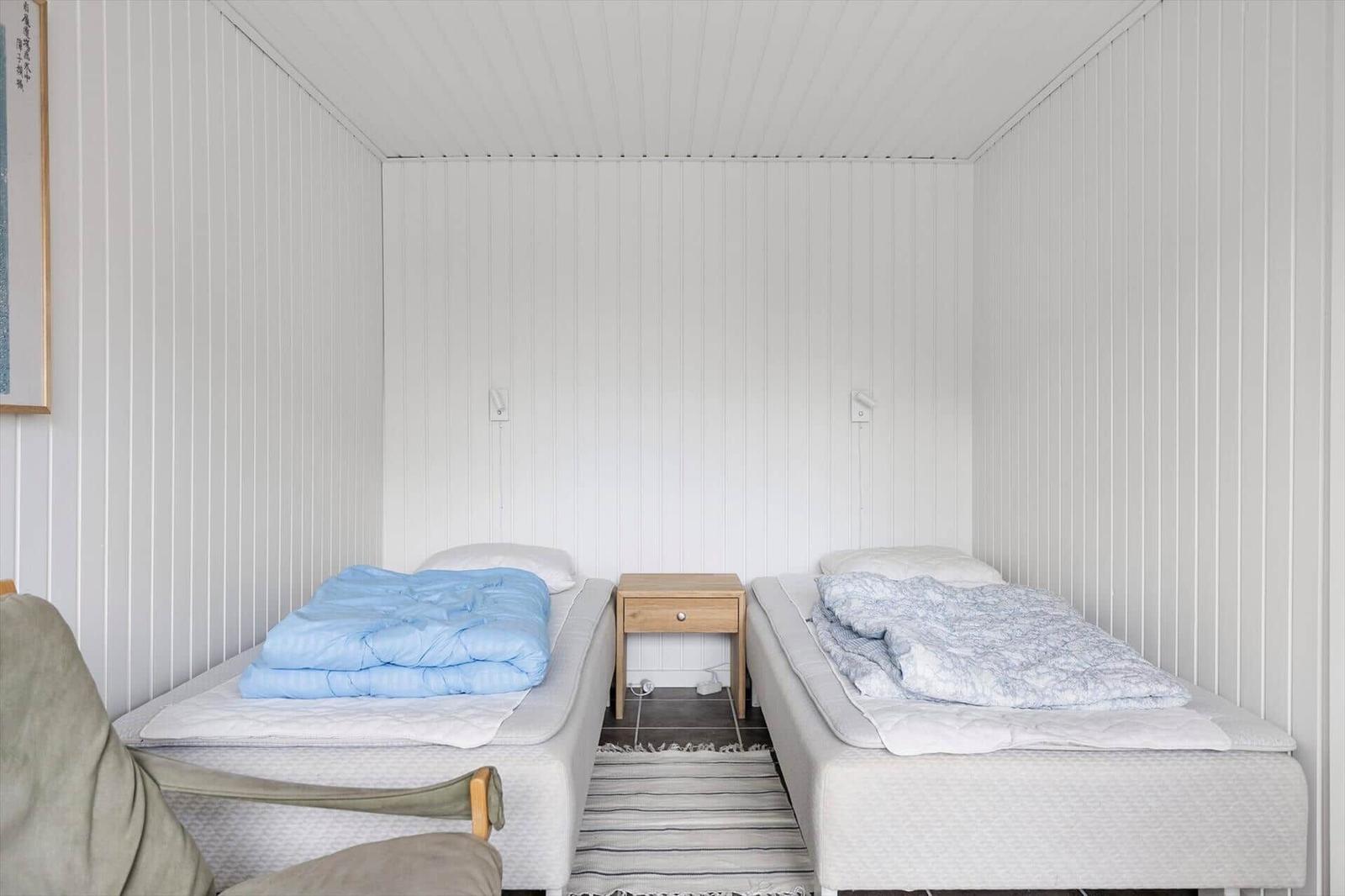 Two single beds with bedding and a nightstand between them.