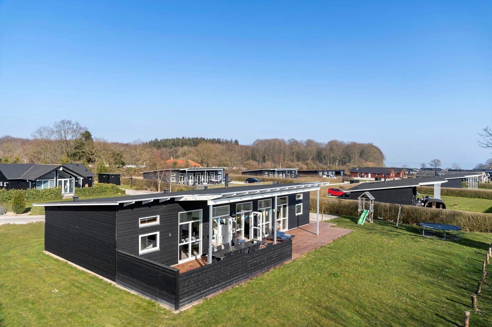 Black holiday home with terrace and garden. Playground and trampoline in the backyard.