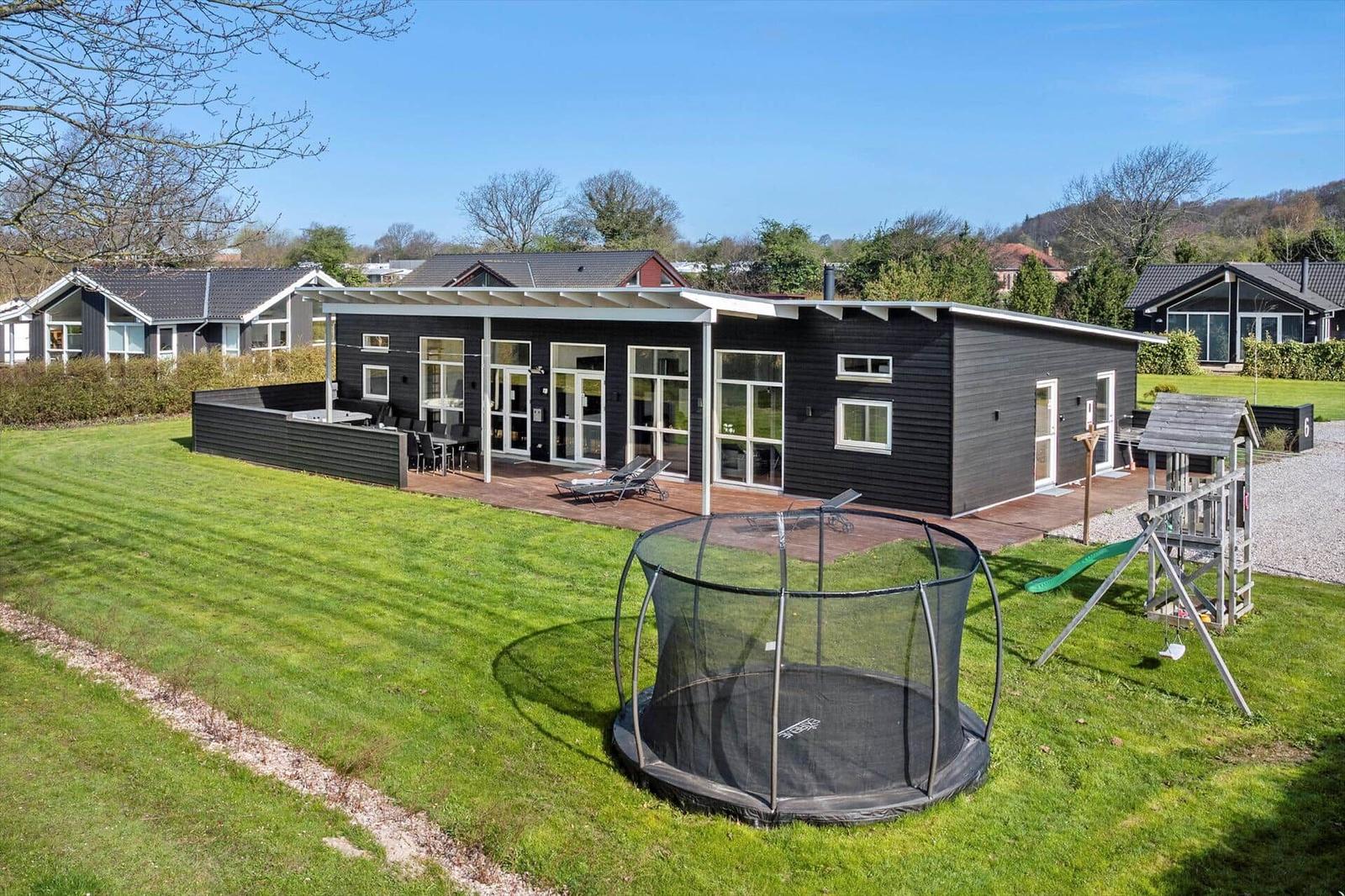 Modern holiday home with large garden, trampoline, and playground.