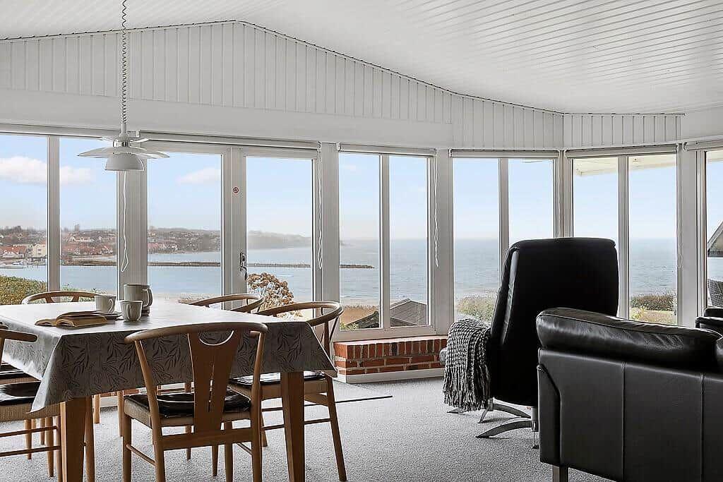 Esszimmer mit Blick aufs Meer und große Fensterfront.