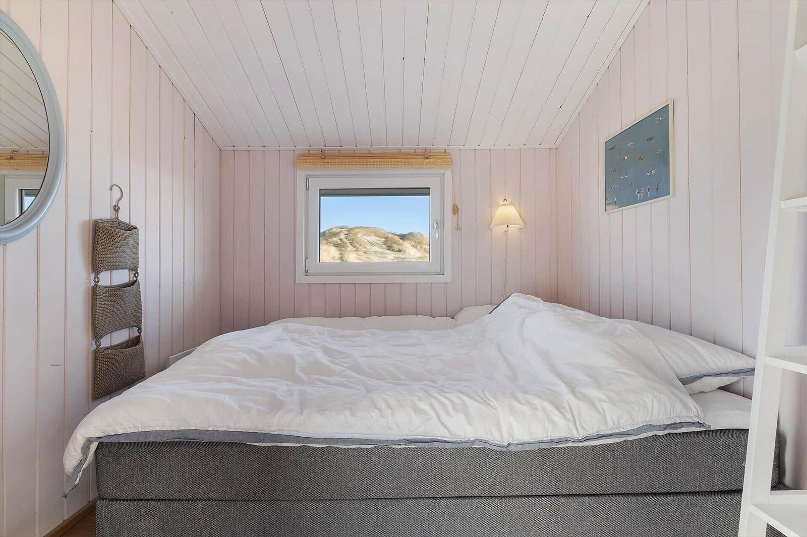 Bedroom with bed, window, and wall art.
