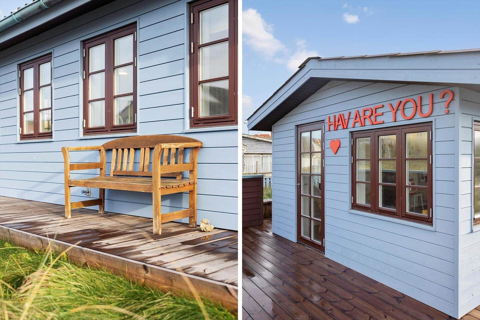 Blue wooden house with bench and sign HAV ARE YOU?