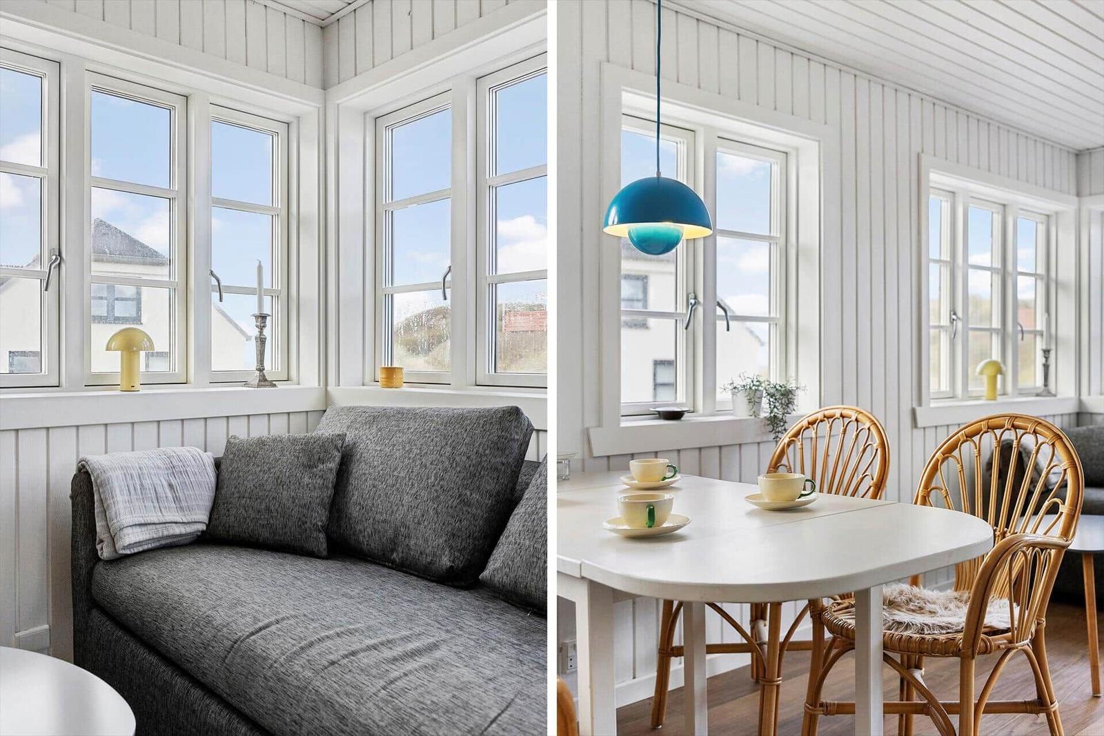 Living area with sofa and windows. Dining area with table, chairs, and lamp.