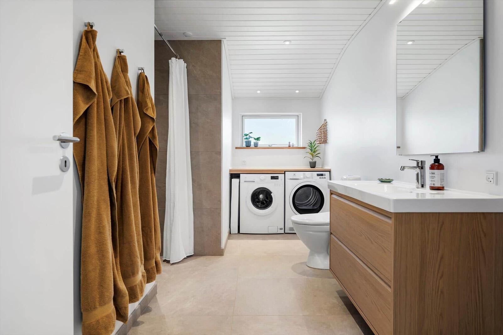 Badezimmer mit Waschmaschine, Trockner und Waschtisch