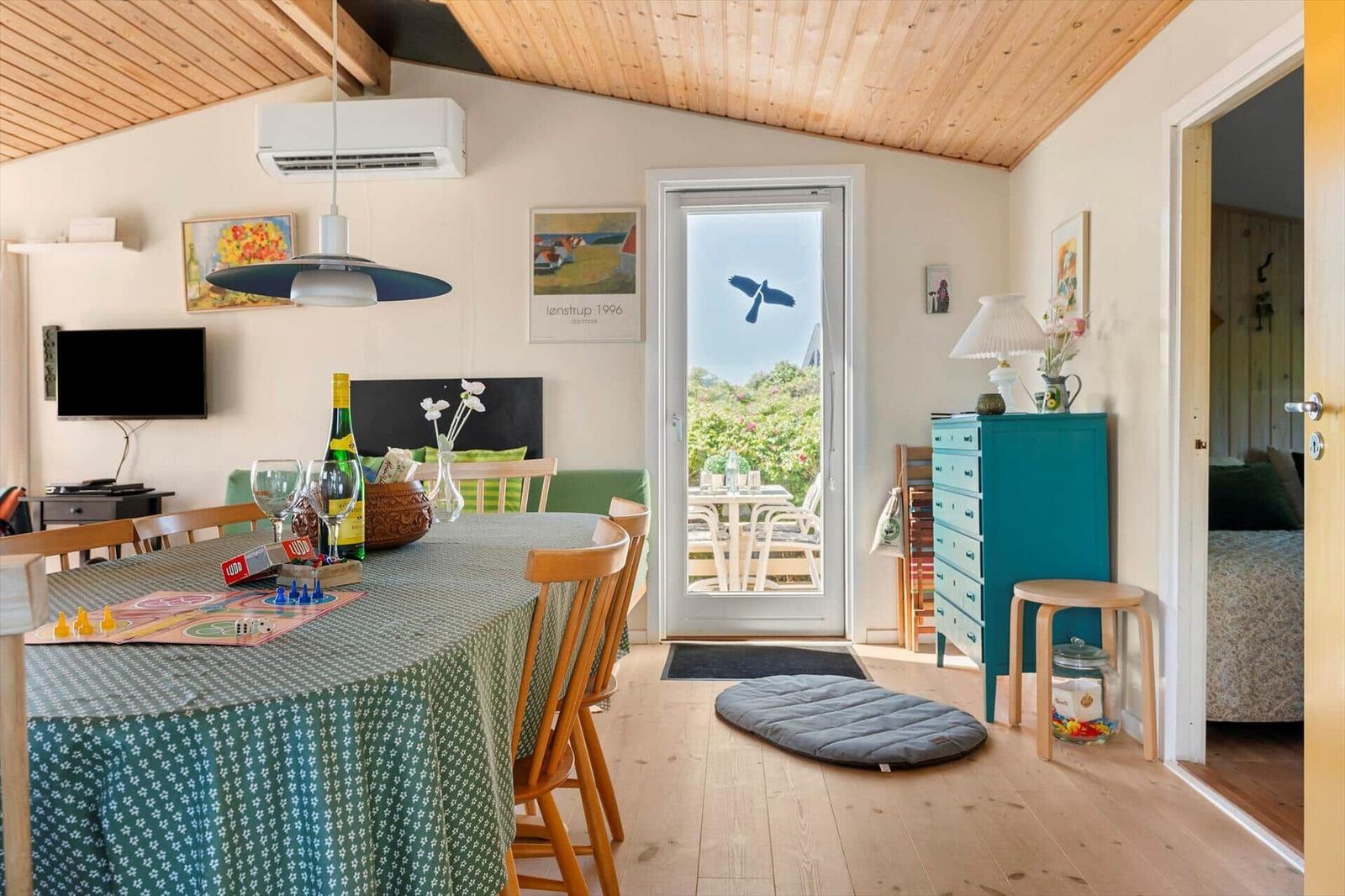 Esszimmer mit Tisch, Stühlen und Blick auf Balkon
