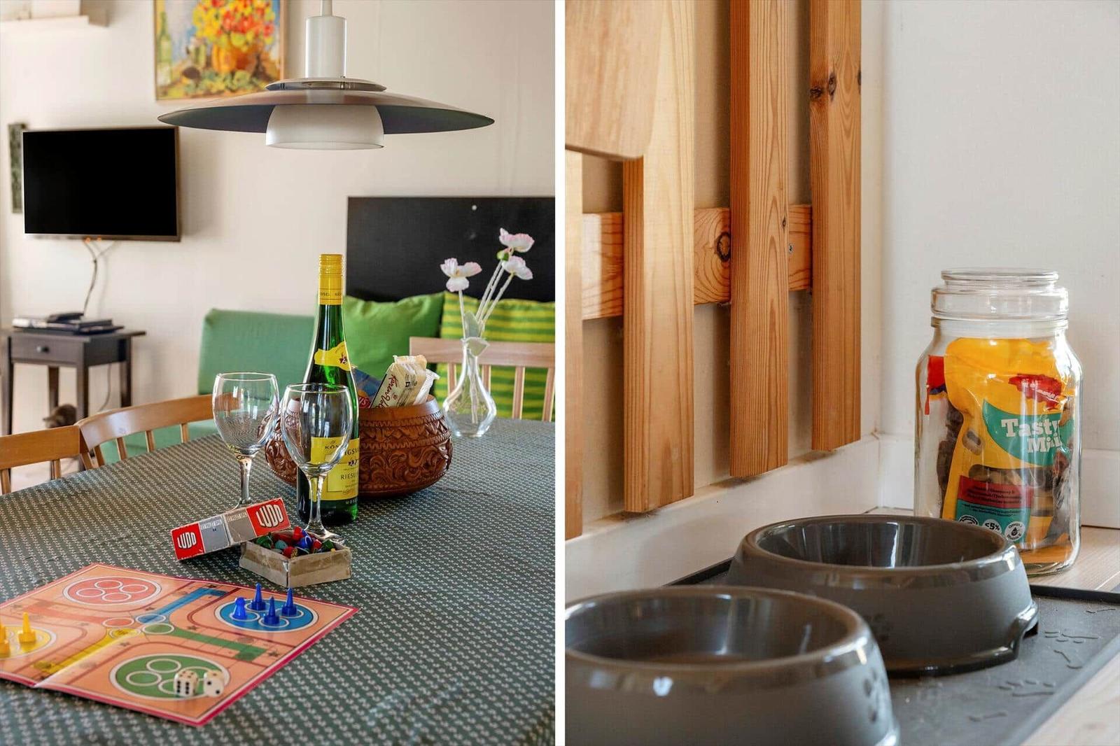 Esstisch mit Spiel und Wein, daneben Hundefutter und Futternapf.