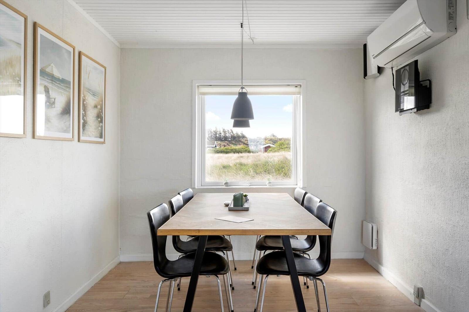 Dining room with table, chairs, and view of green fields