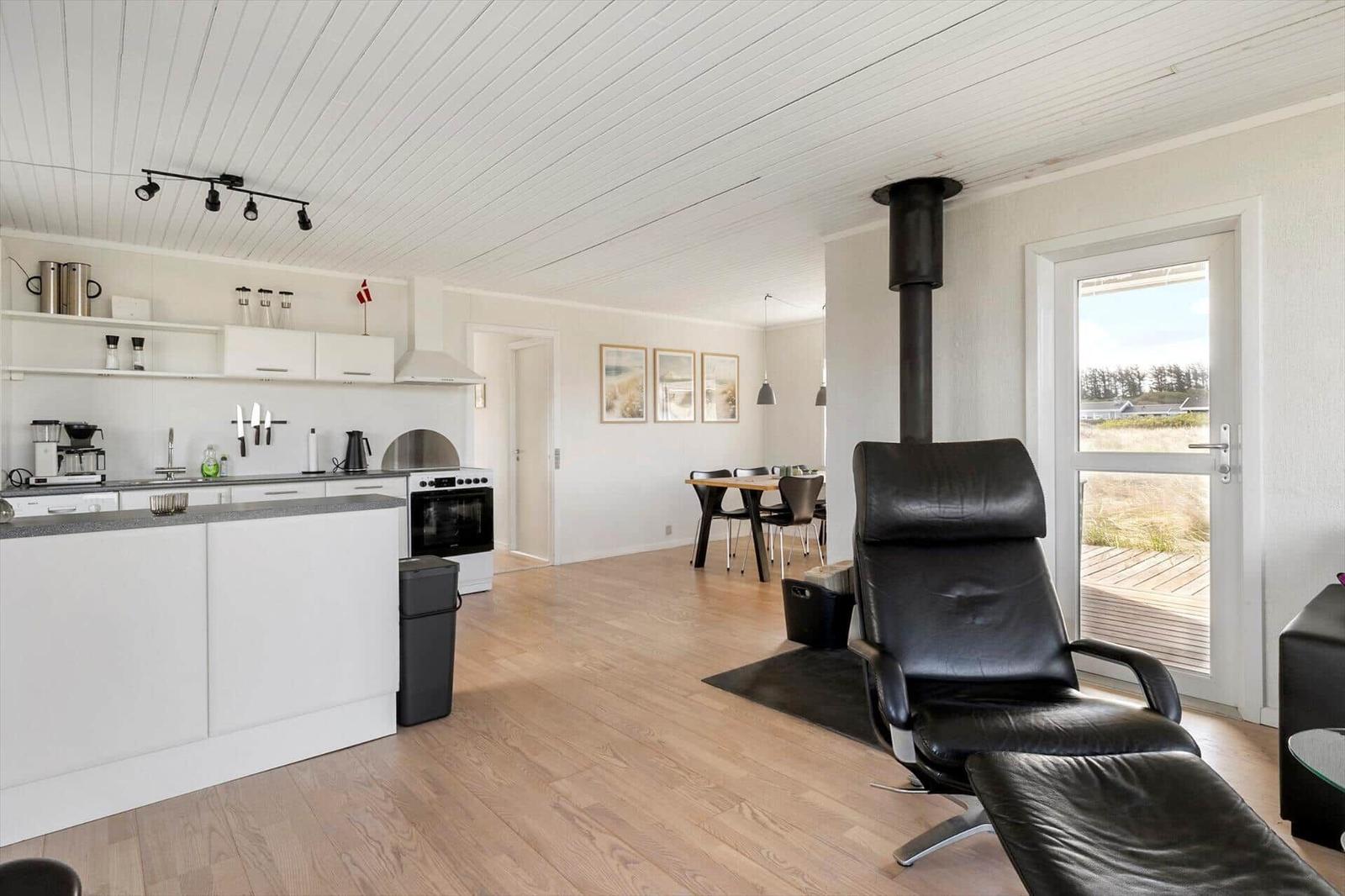 Kitchen, dining area, and seating with view to the terrace.