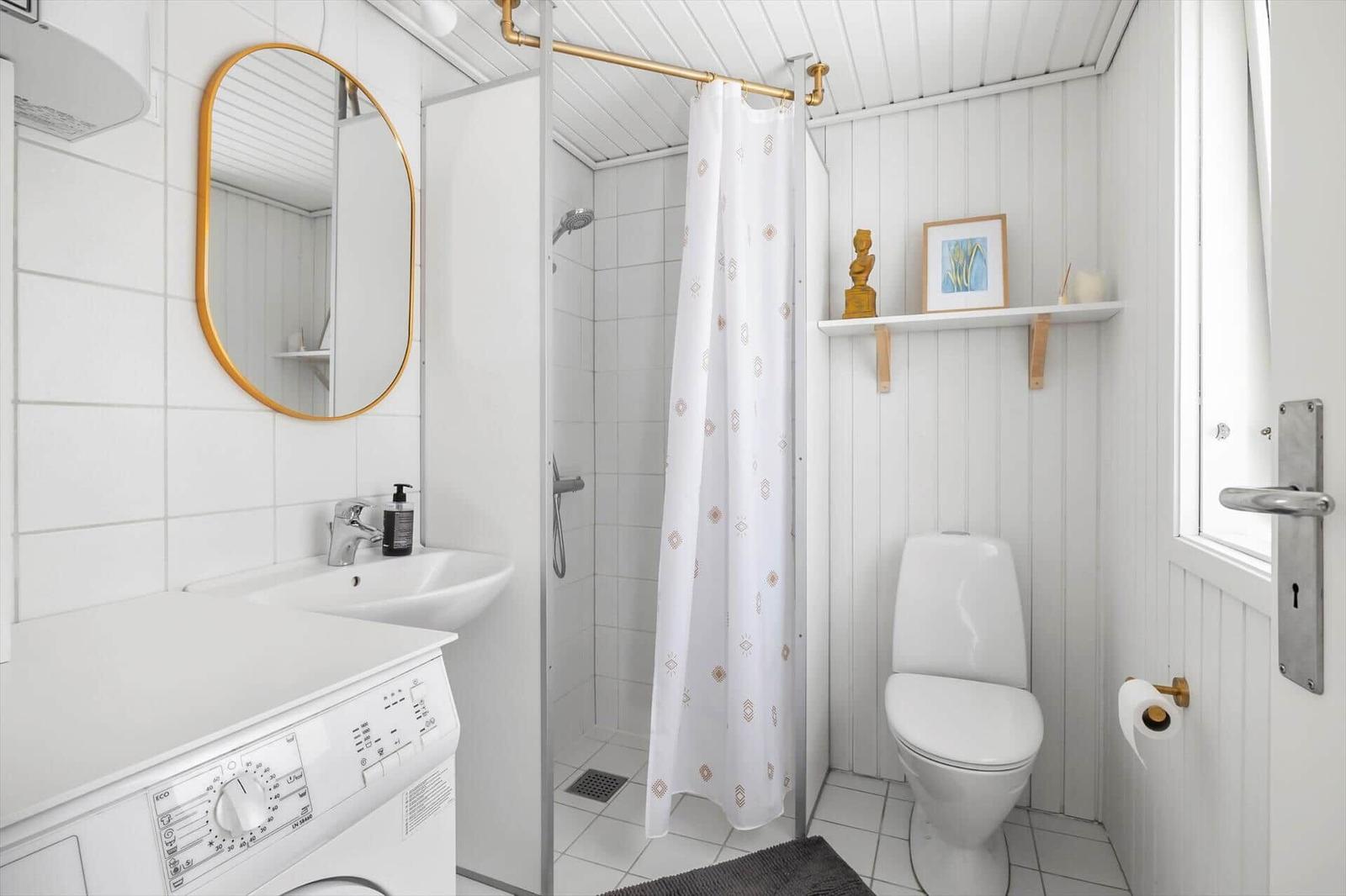 Bathroom with shower, toilet, sink, and washing machine.