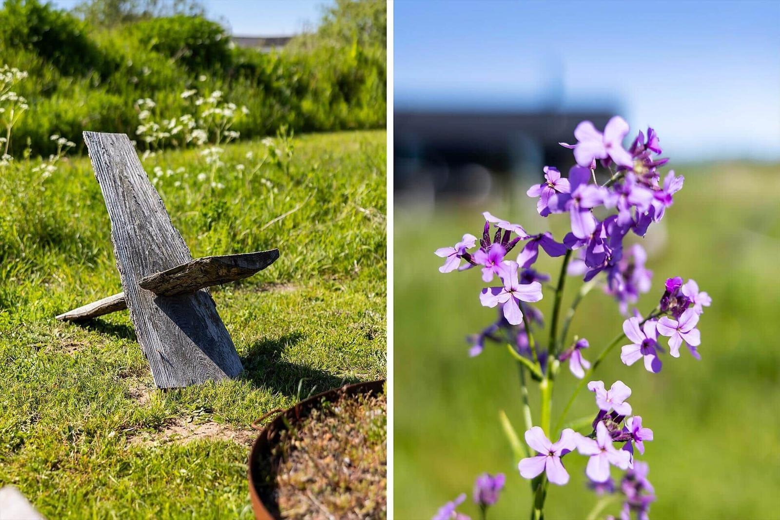 Wooden anchor on grass and purple flowers outdoors