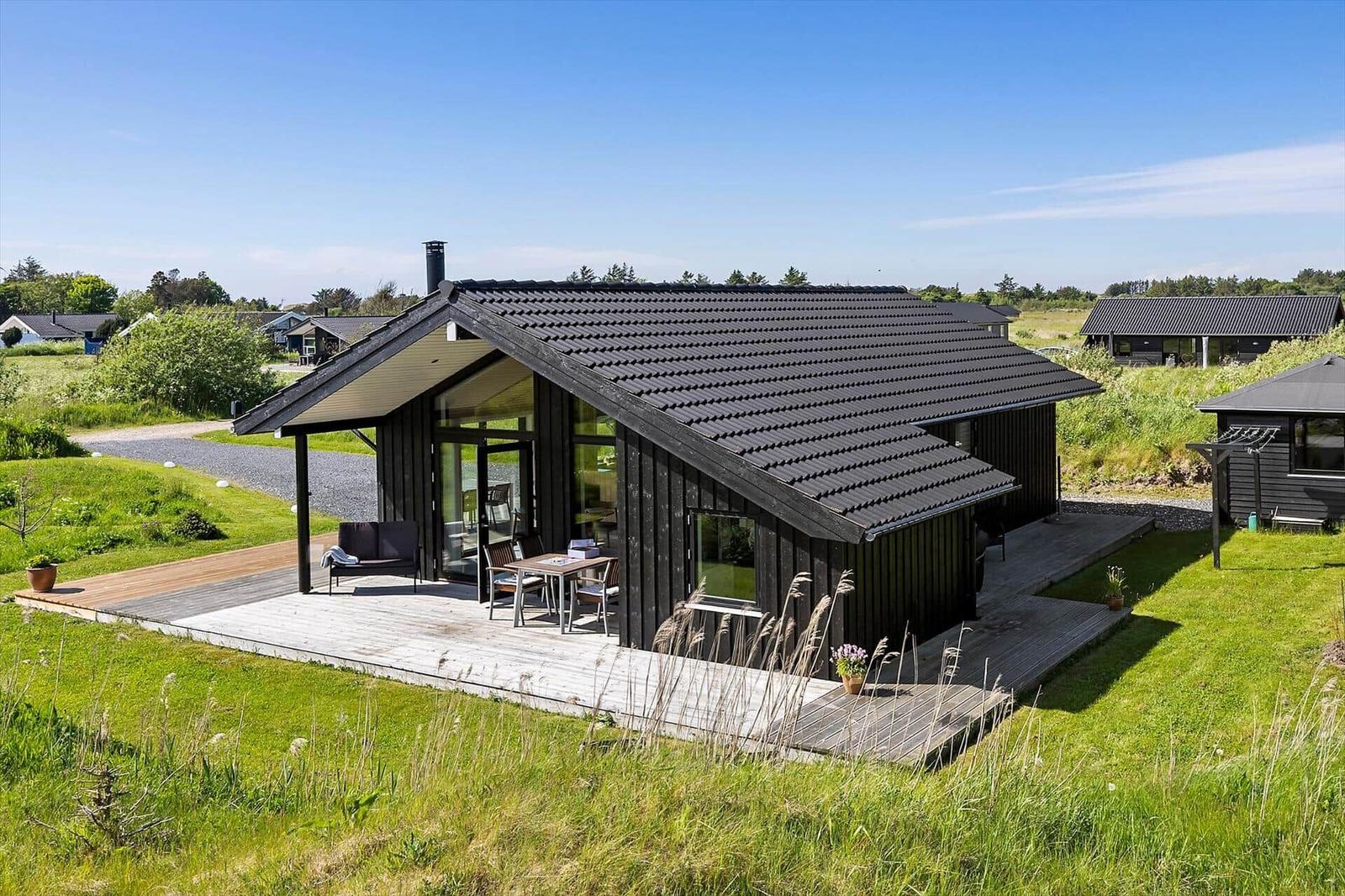 Modern wooden house with terrace and garden. View of the surroundings.
