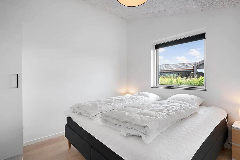 Schlafzimmer mit Bett, Fenster und Holzboden