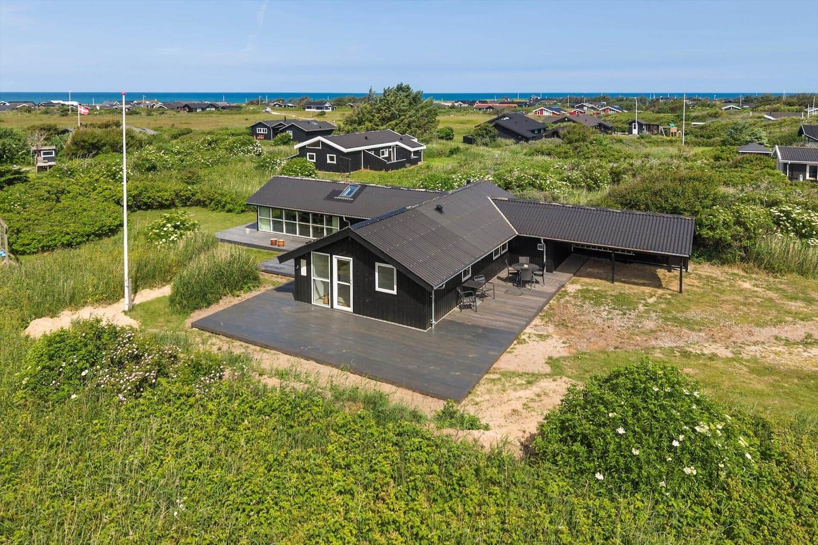 Schwarzes Ferienhaus mit Terrasse und Blick aufs Meer