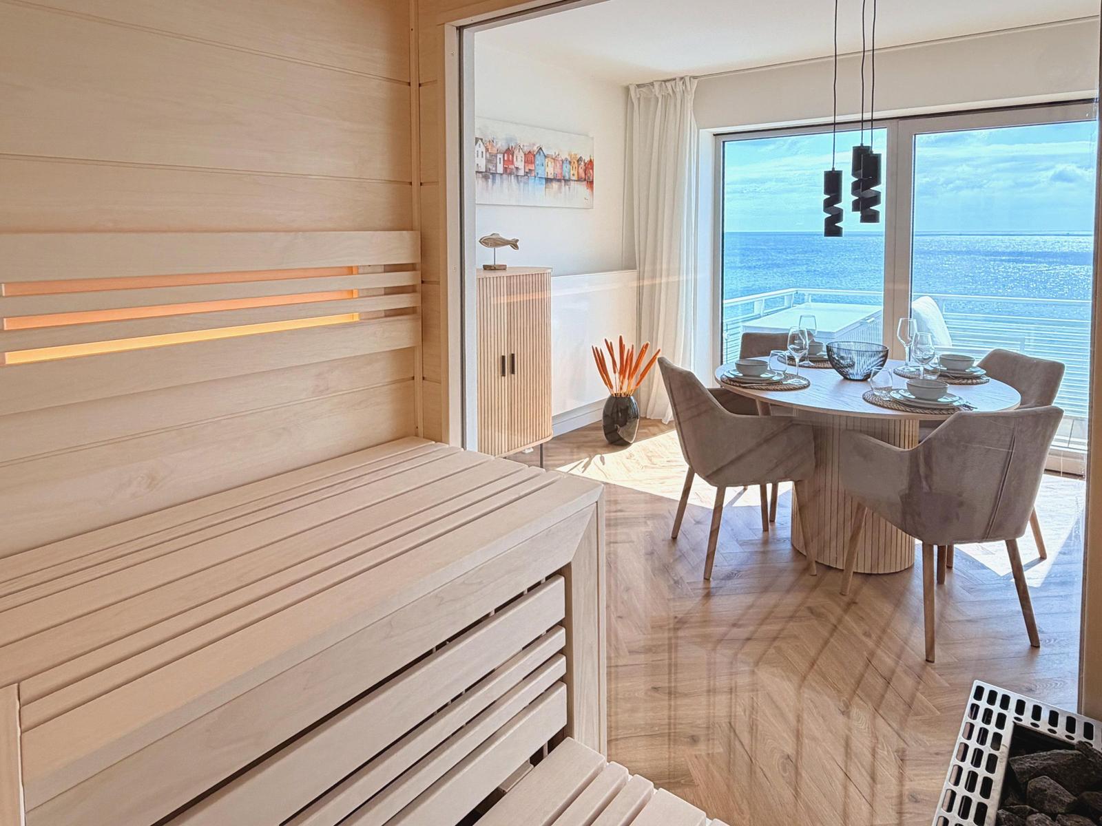 Sauna mit Holzbank und Blick auf Essbereich mit Meerblick.