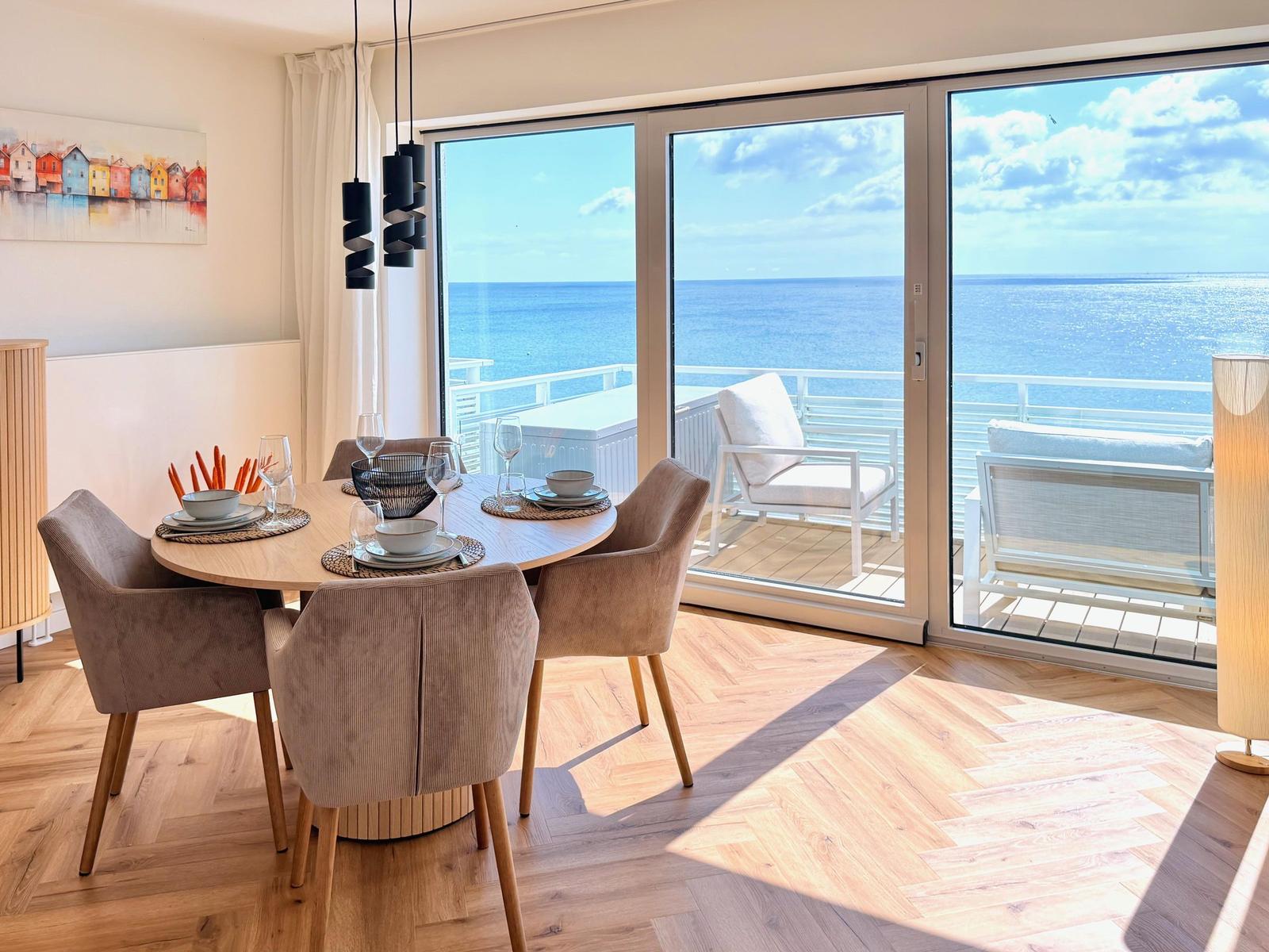 Essbereich mit Blick aufs Meer und Balkon mit Sitzgelegenheiten.