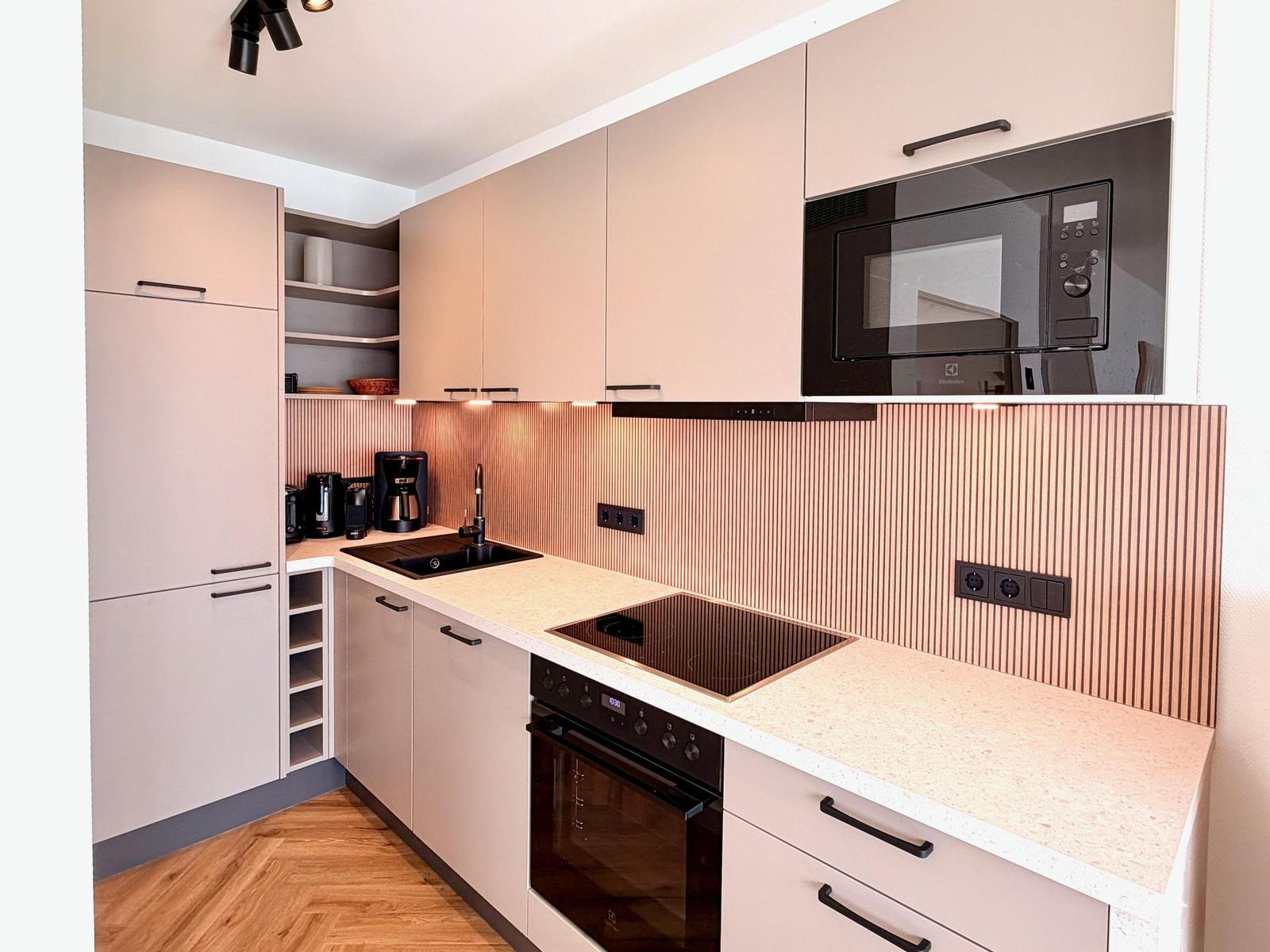 Moderne Küche mit integriertem Mikrowellenherd und Edelstahlspüle.