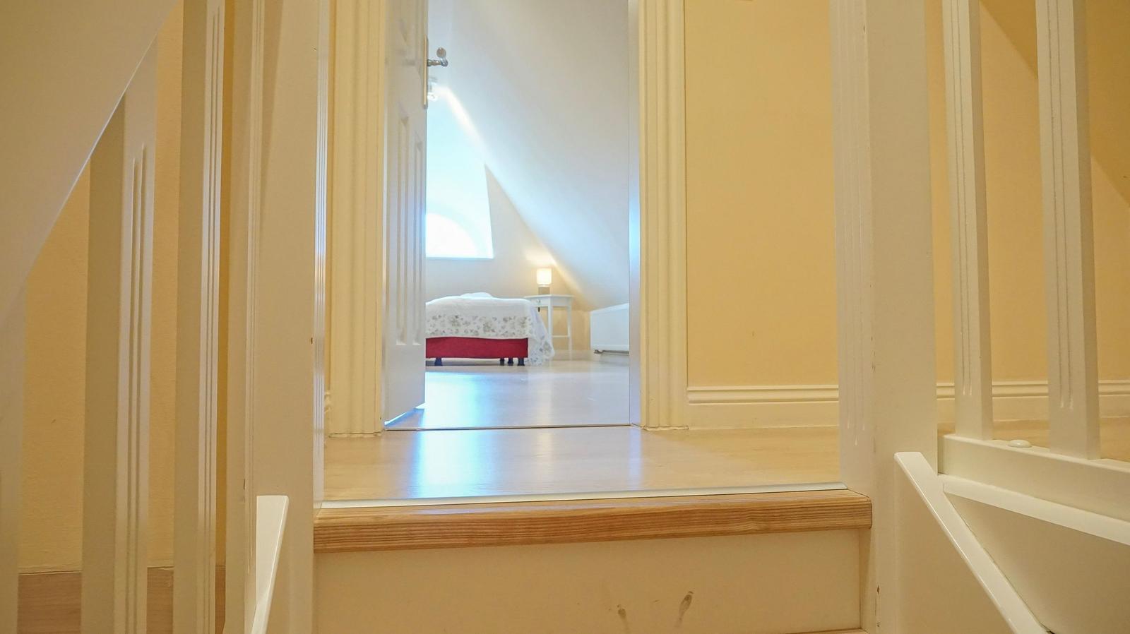 Durchgang zu einem Schlafzimmer mit Bett und Fenster