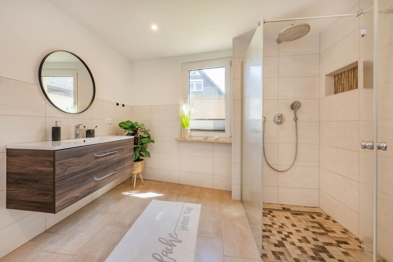 Badezimmer mit Dusche, Waschbecken und Fenster