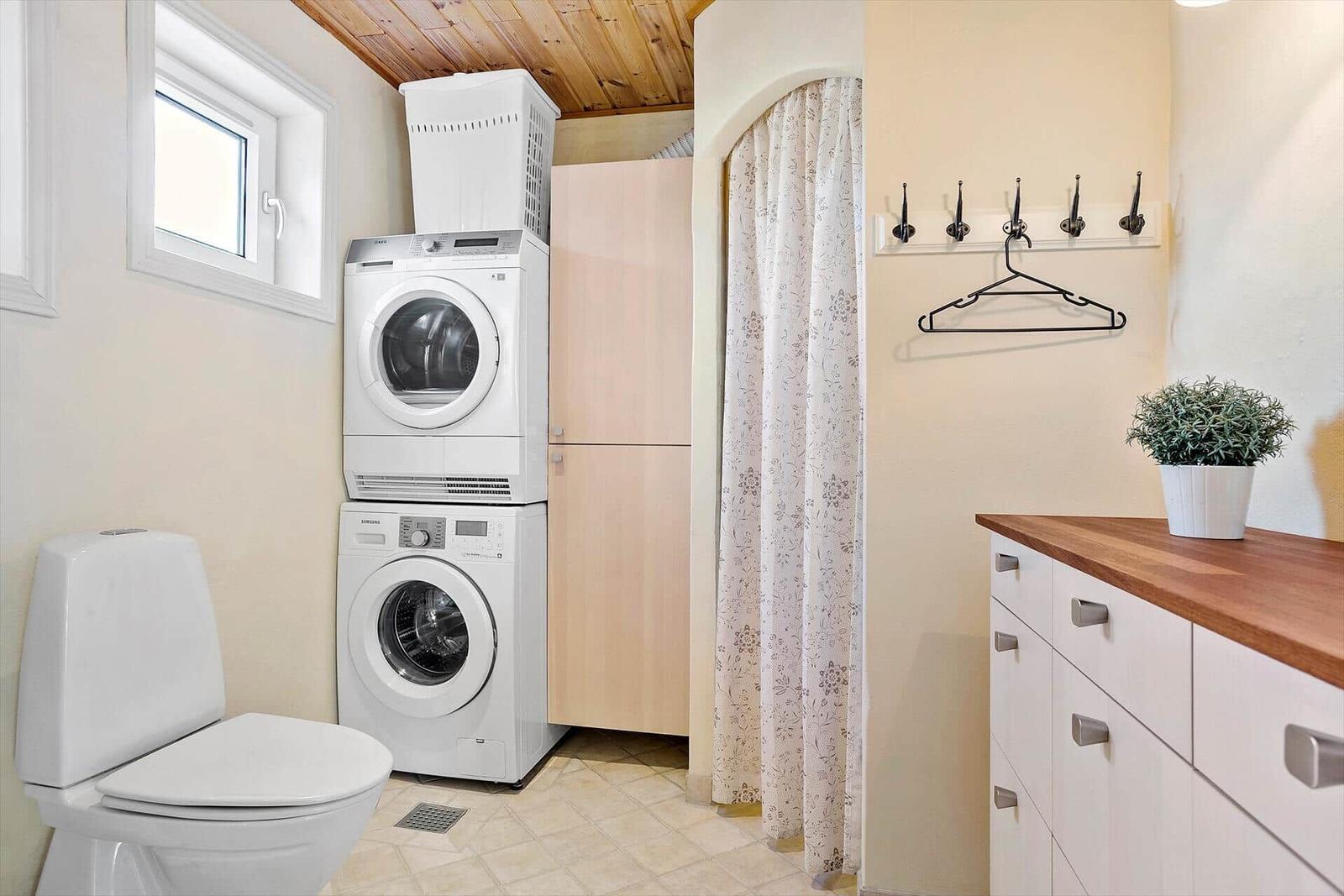 Wohnung mit Waschmaschine, Trockner, Toilette und Garderobe.