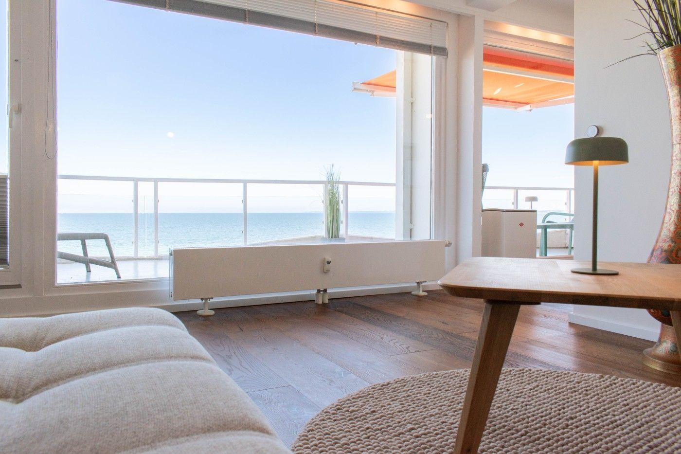 Wohnzimmer mit Blick aufs Meer und Balkon mit Liege