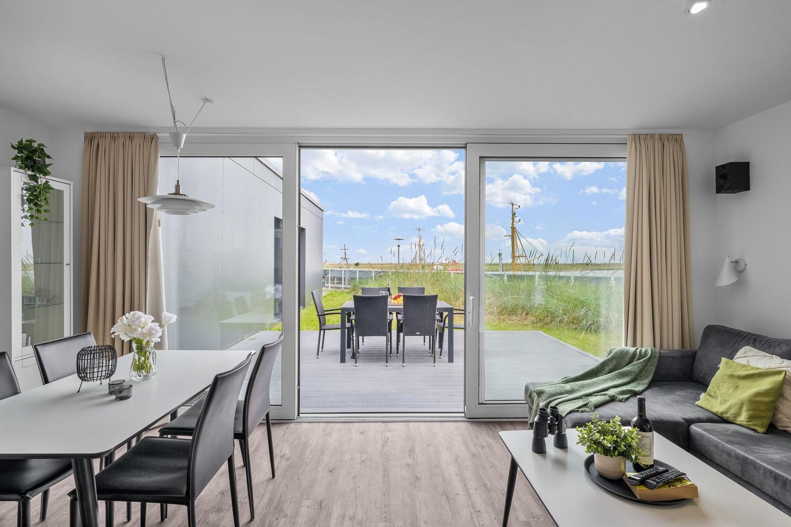 Wohn- und Essbereich mit Blick auf Terrasse und Grünland.