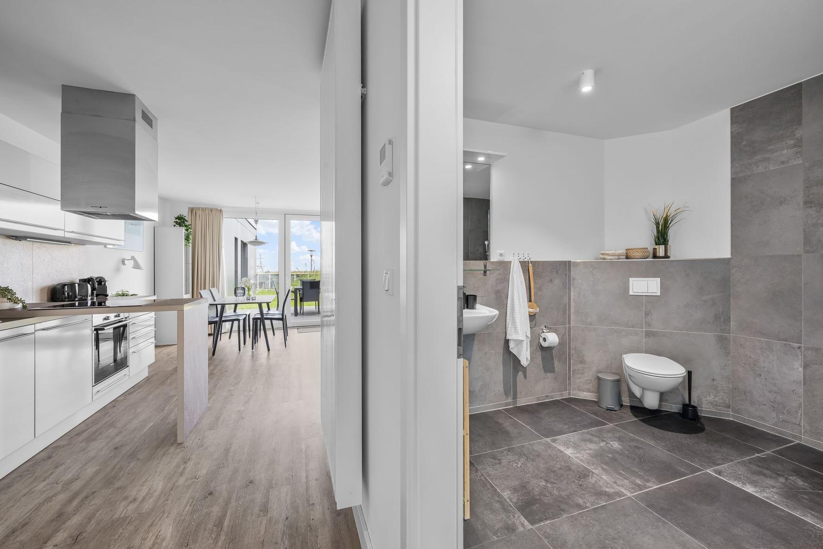 Küche mit Essbereich und Badezimmer mit Toilette und Waschbecken