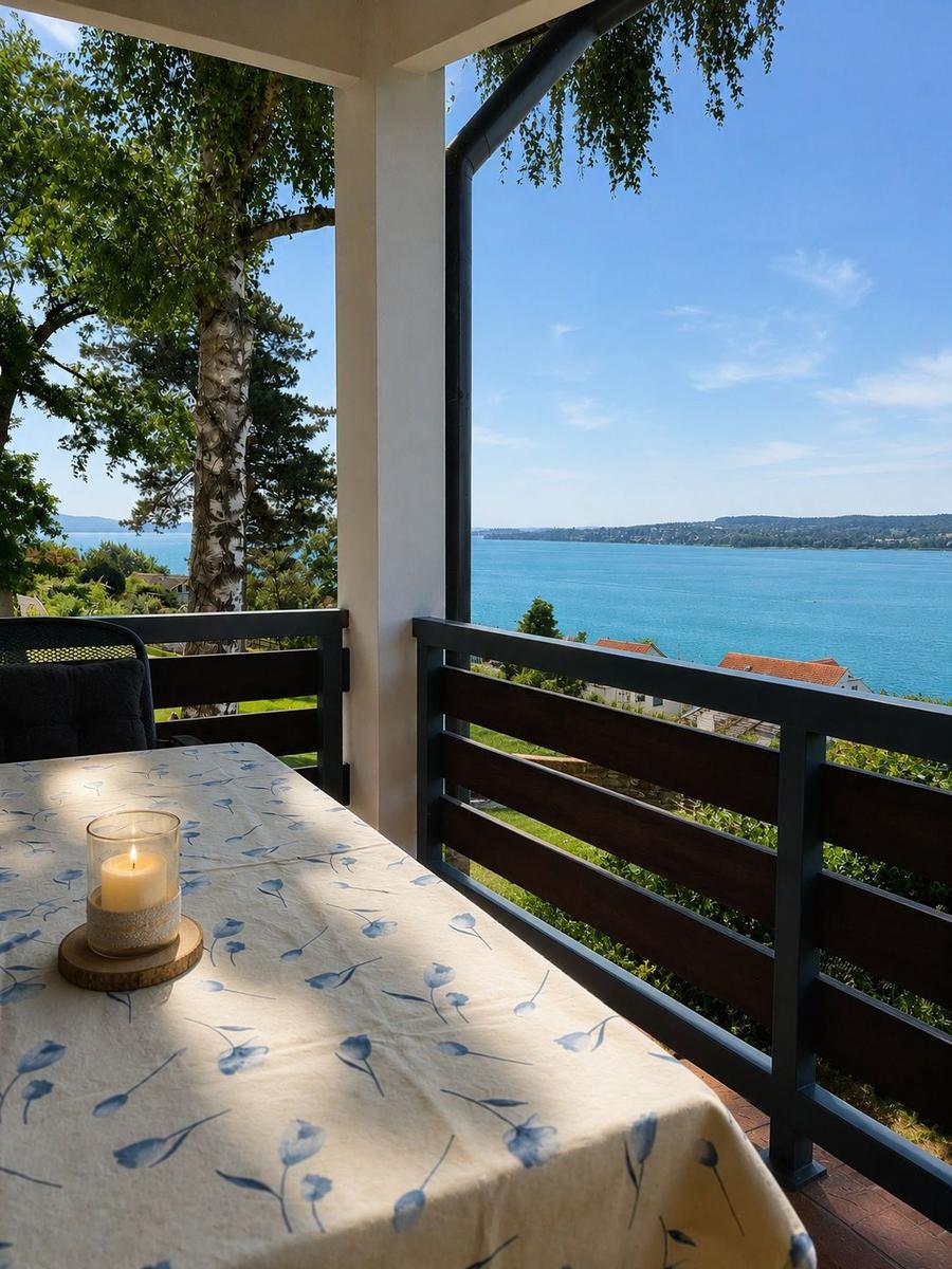Tisch mit Kerze auf Balkon mit Blick auf See und Landschaft