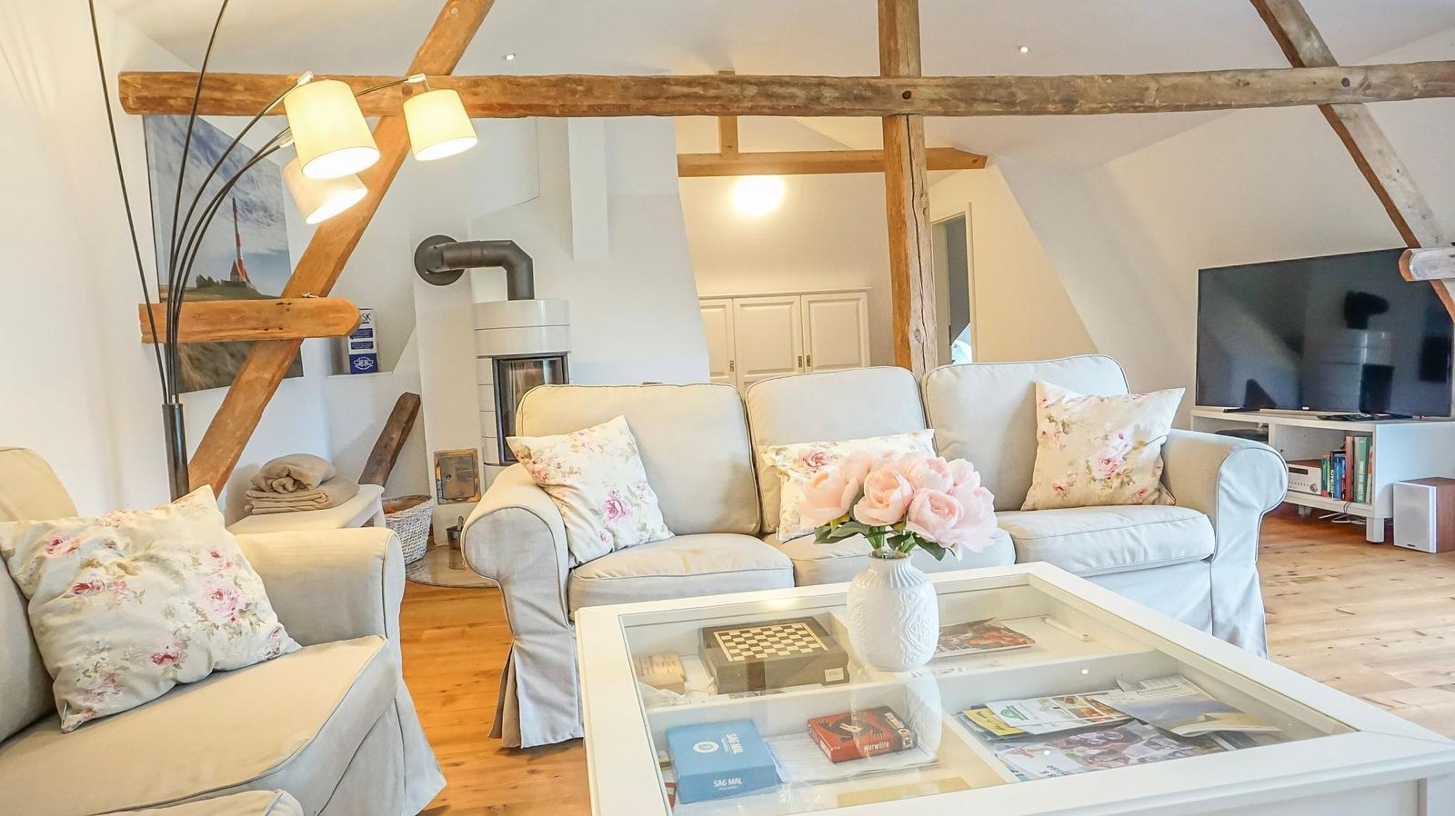 Wohnzimmer mit Sofa, Couchtisch und Holzbalken an der Decke.