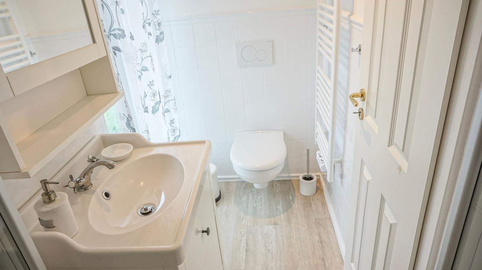 Badezimmer mit Waschbecken, Toilette und Duschvorhang.