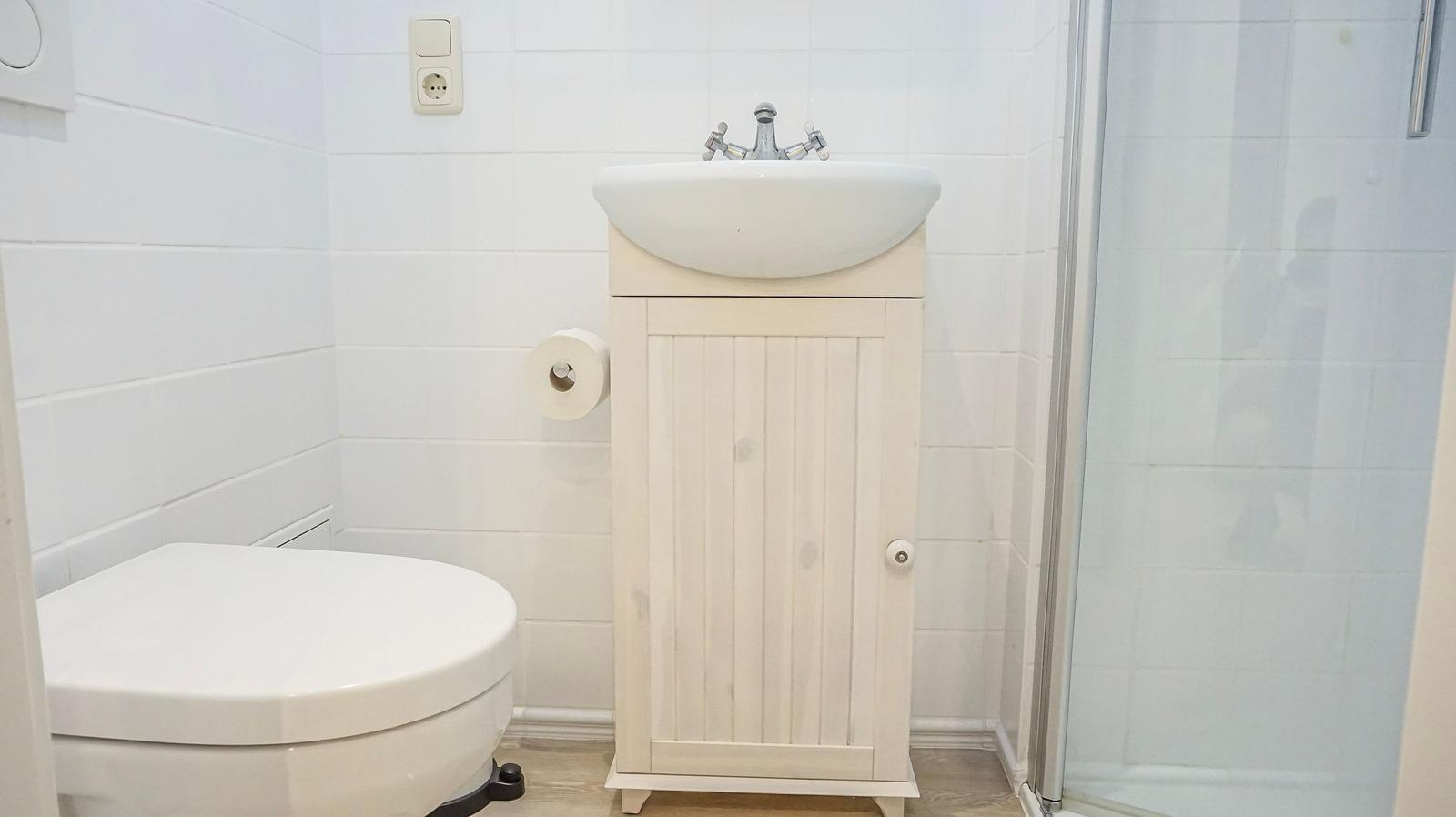 Badezimmer mit Toilette, Waschbecken und Dusche.
