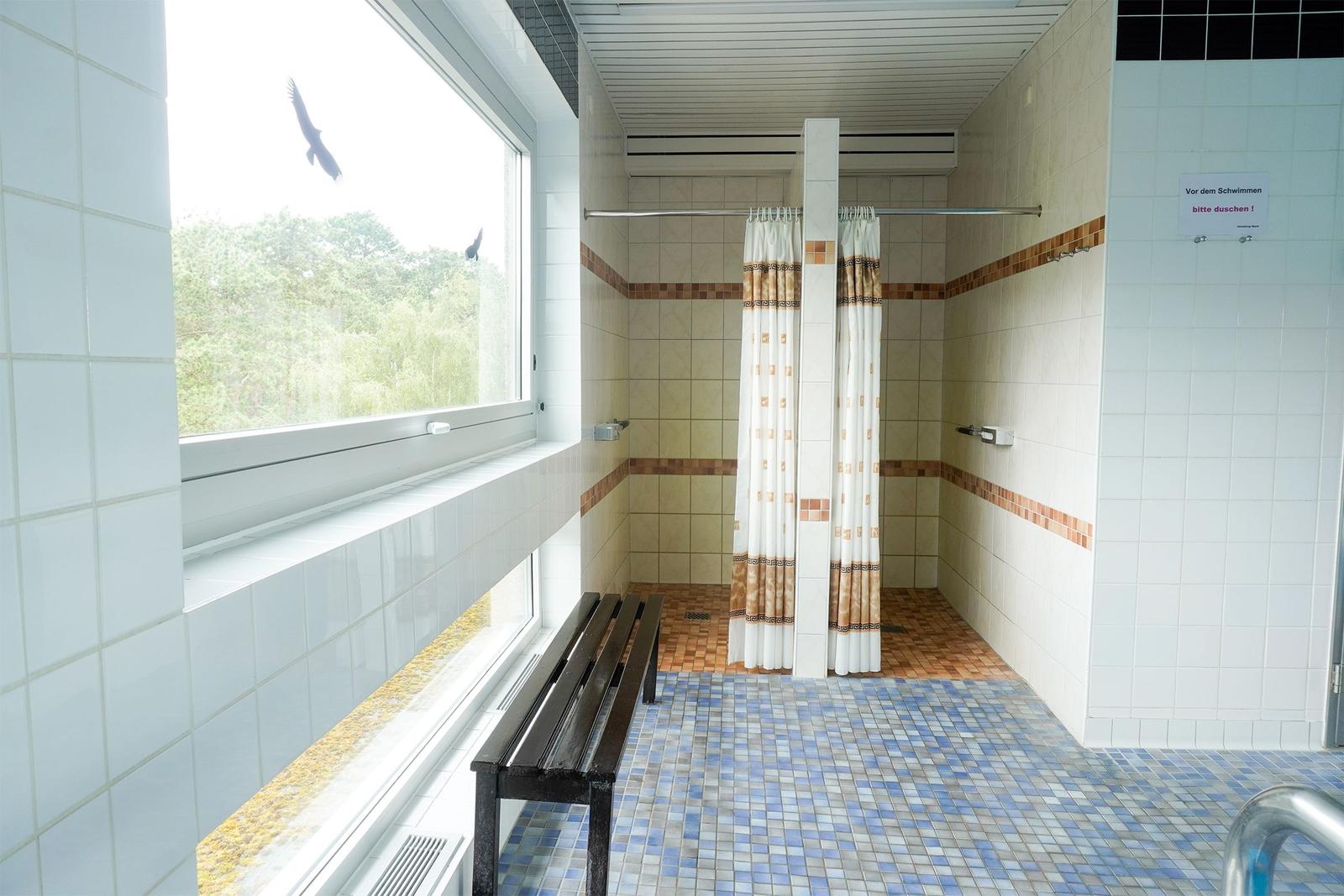 Duschkabine mit Fenster, Bank und Duschvorhang. Vor dem Schwimmen bitte duschen.