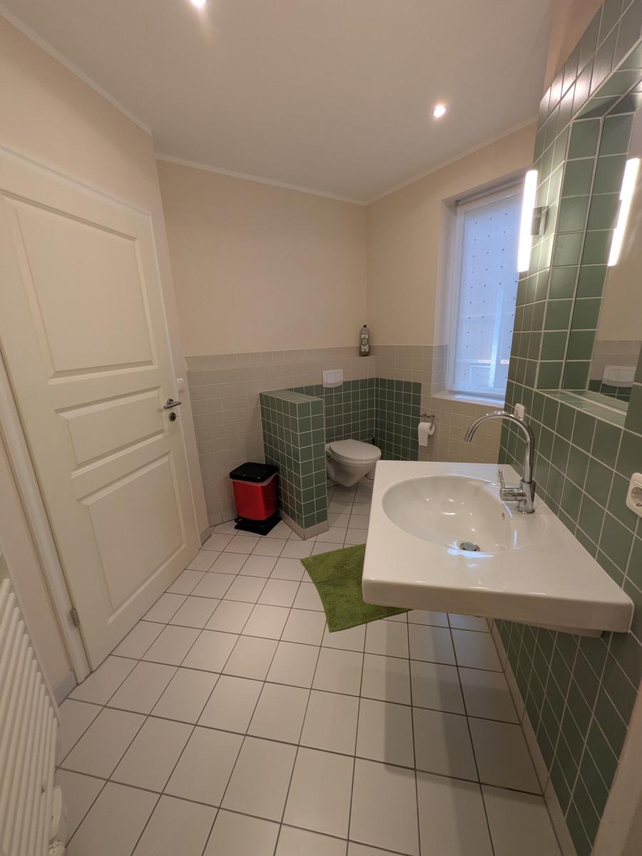 Badezimmer mit Waschbecken, Toilette und Fenster