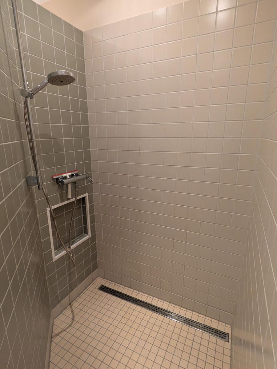 Dusche mit Duschbrause und Bodenablauf