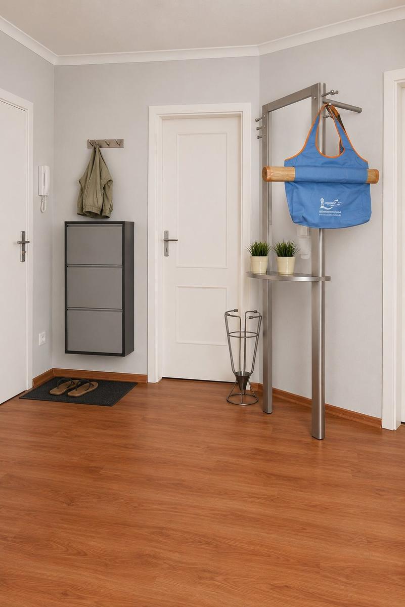 Eingangsbereich mit Kleiderhaken, Schuhschrank und Ständer mit Tasche.