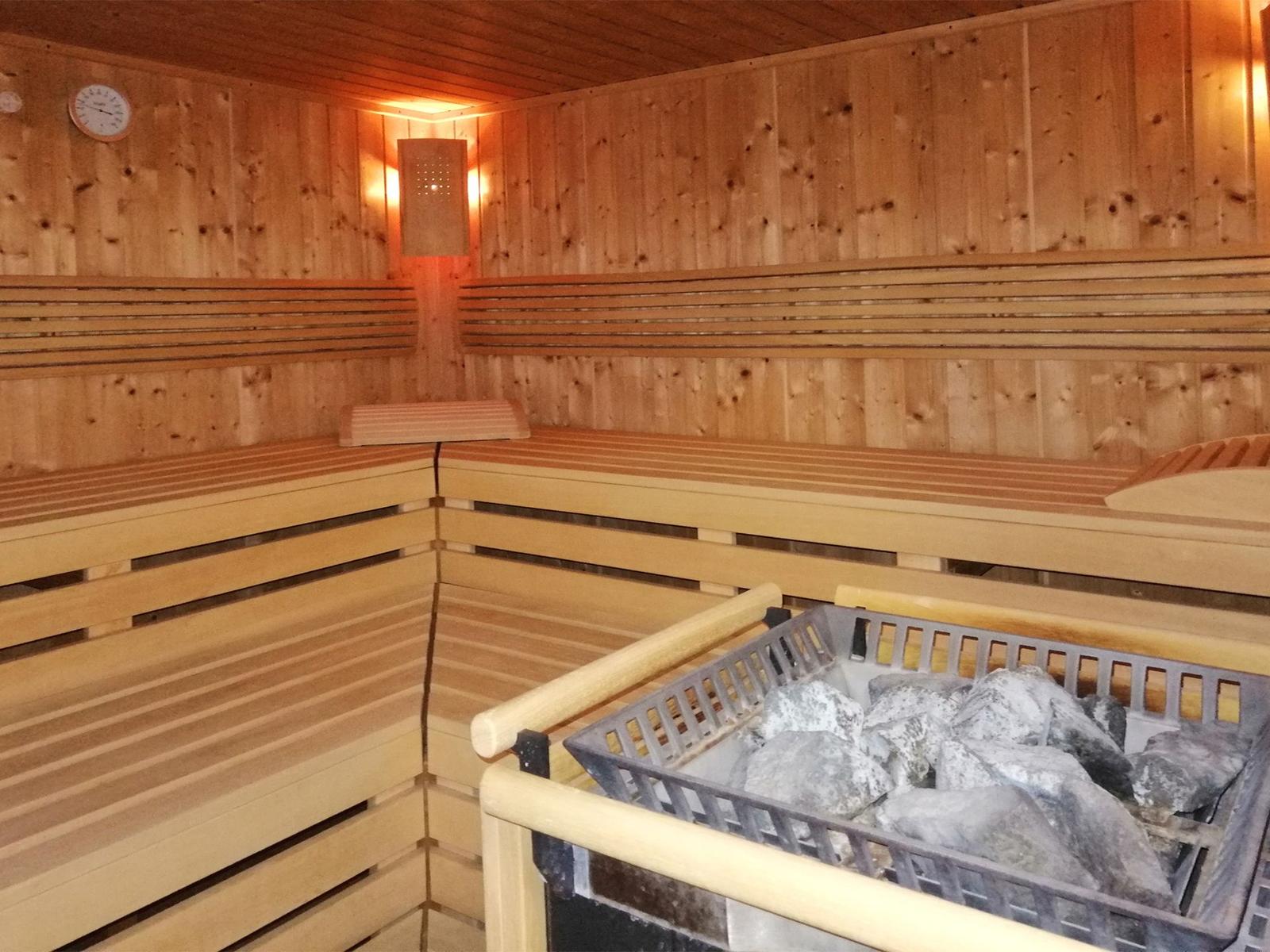Holzsauna mit Sitzbänken und Steinmulde
