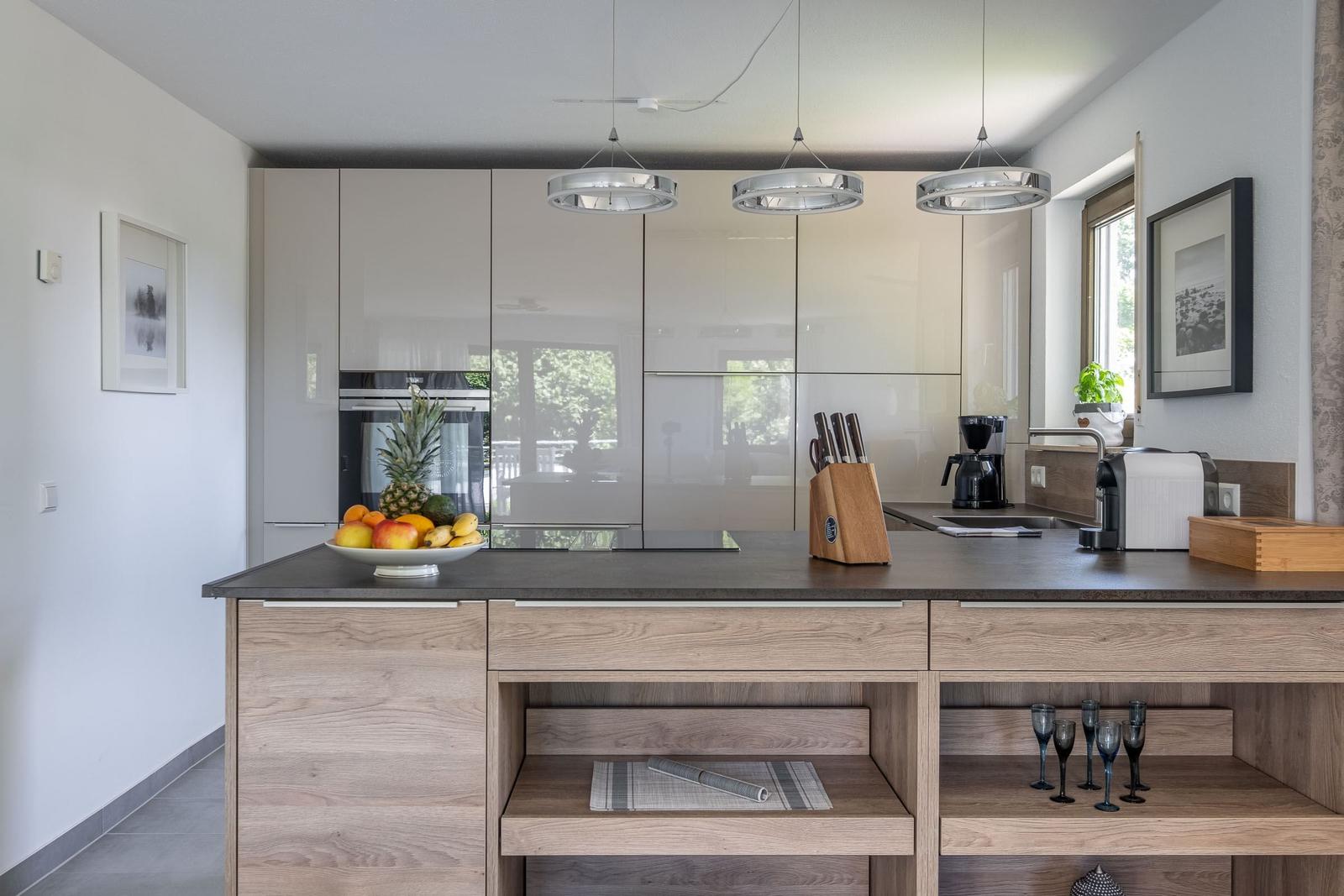 Moderne Küche mit Holzinsel, Glasküchen und Obstschale.