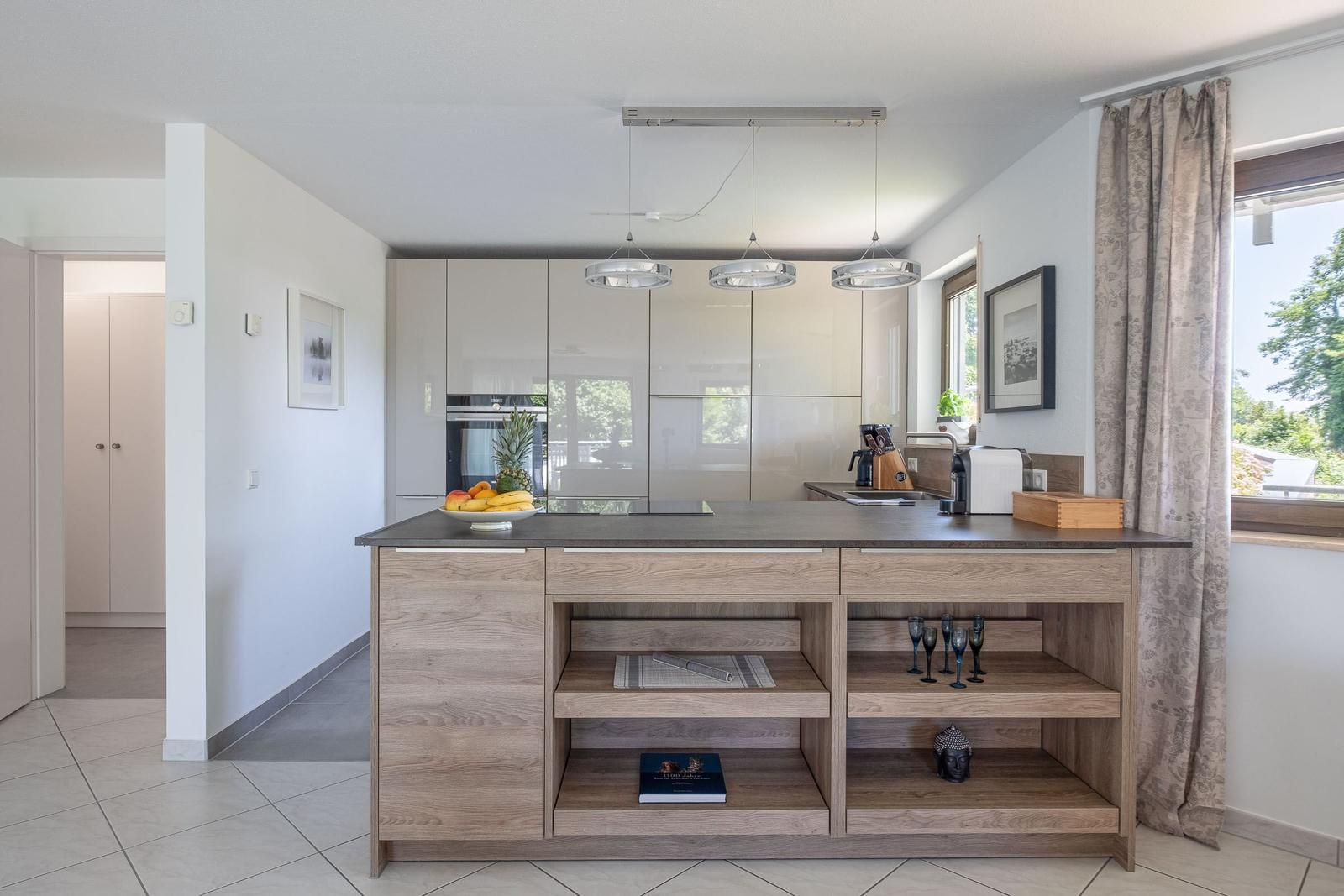 Küche mit Holzinsel, Schränken und Fensterblick