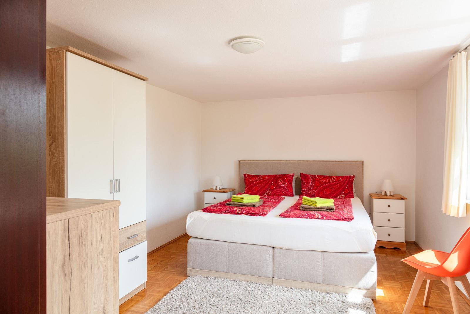 Schlafzimmer mit Bett, Nachttischen und Schrank. Auf dem Bett liegen Handtücher.