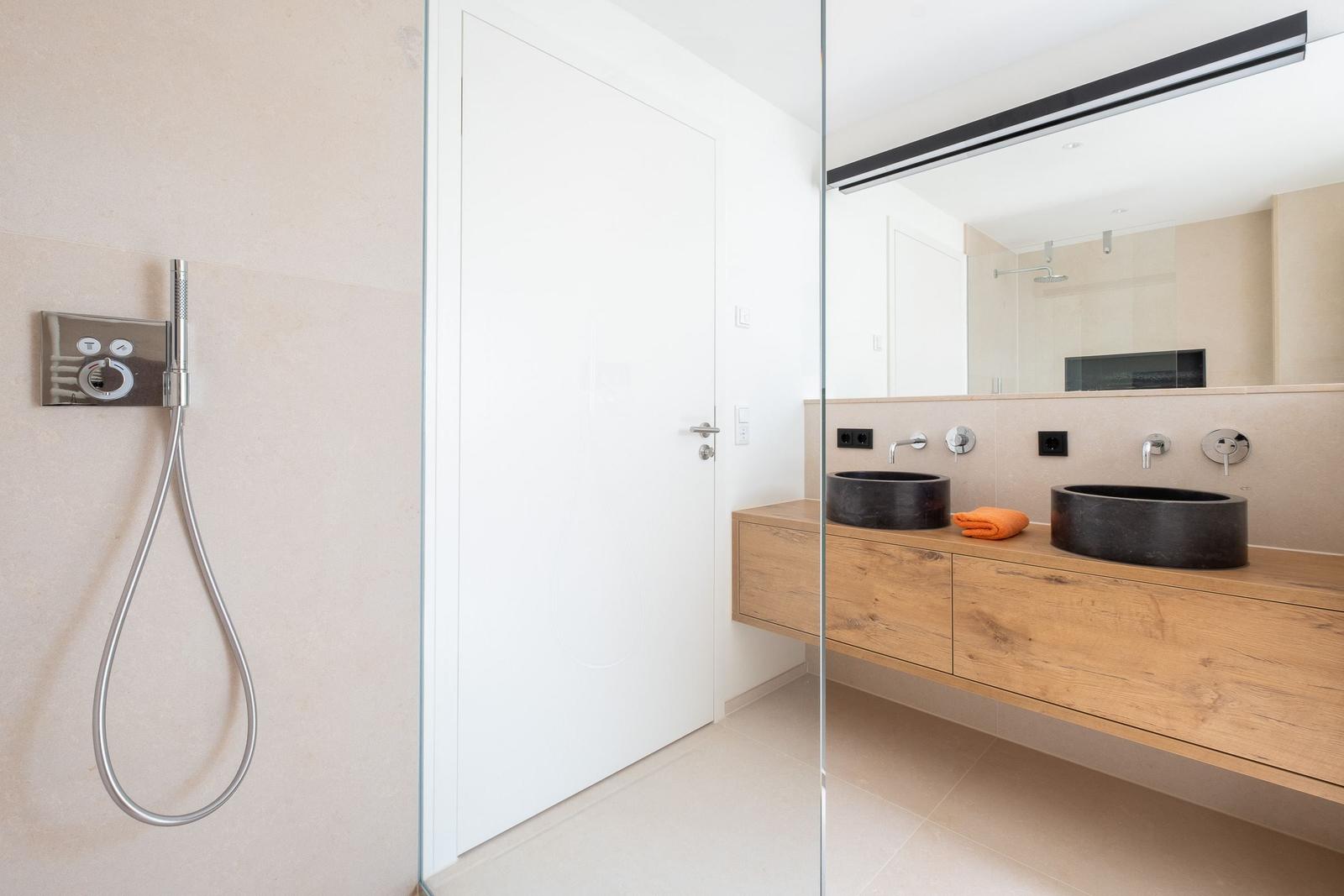 Bad mit Dusche, zwei Waschbecken und Holzwaschtisch