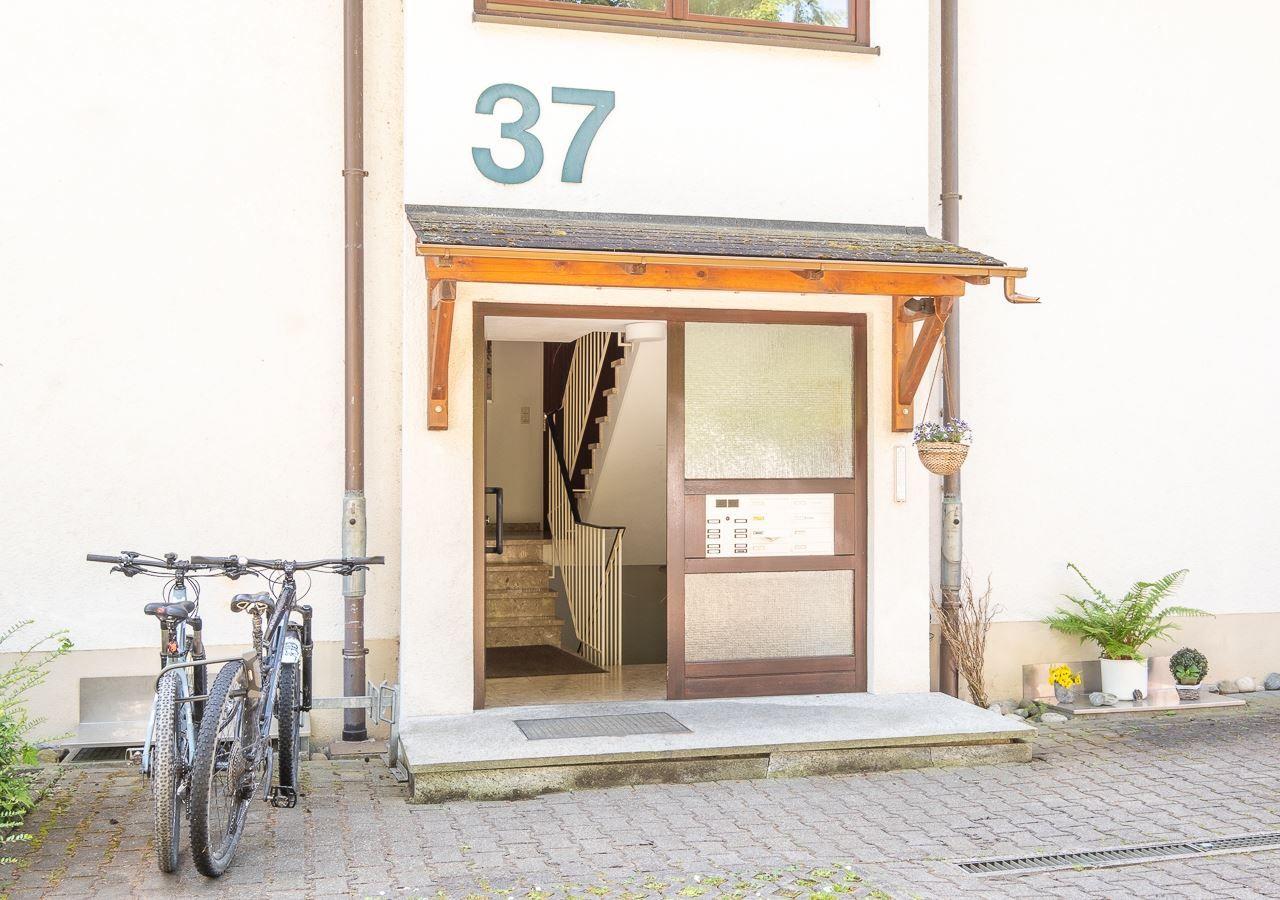 Eingang mit Hausnummer 37, Fahrräder und Pflanzen vor der Tür.