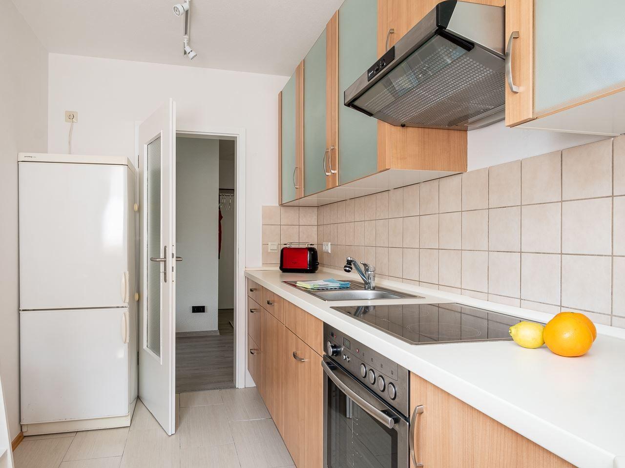 Küche mit Kühlschrank, Herd, Spüle und Küchenzeile.