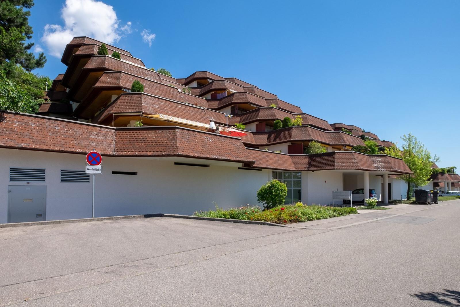 Terrassenwohnung mit rotem Dach und Gartenbereich