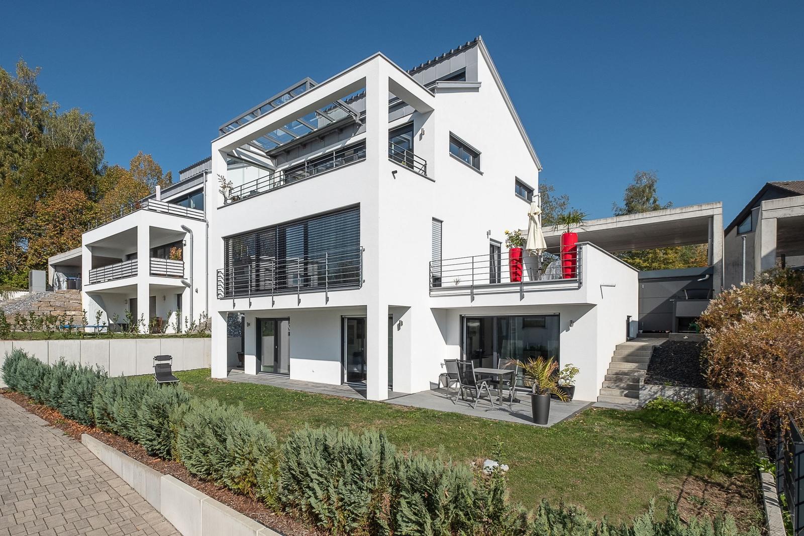 Moderne weiße Villa mit Terrasse und Garten.