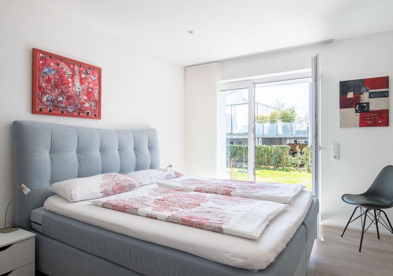 Schlafzimmer mit Bett, Fenster und Wandkunst