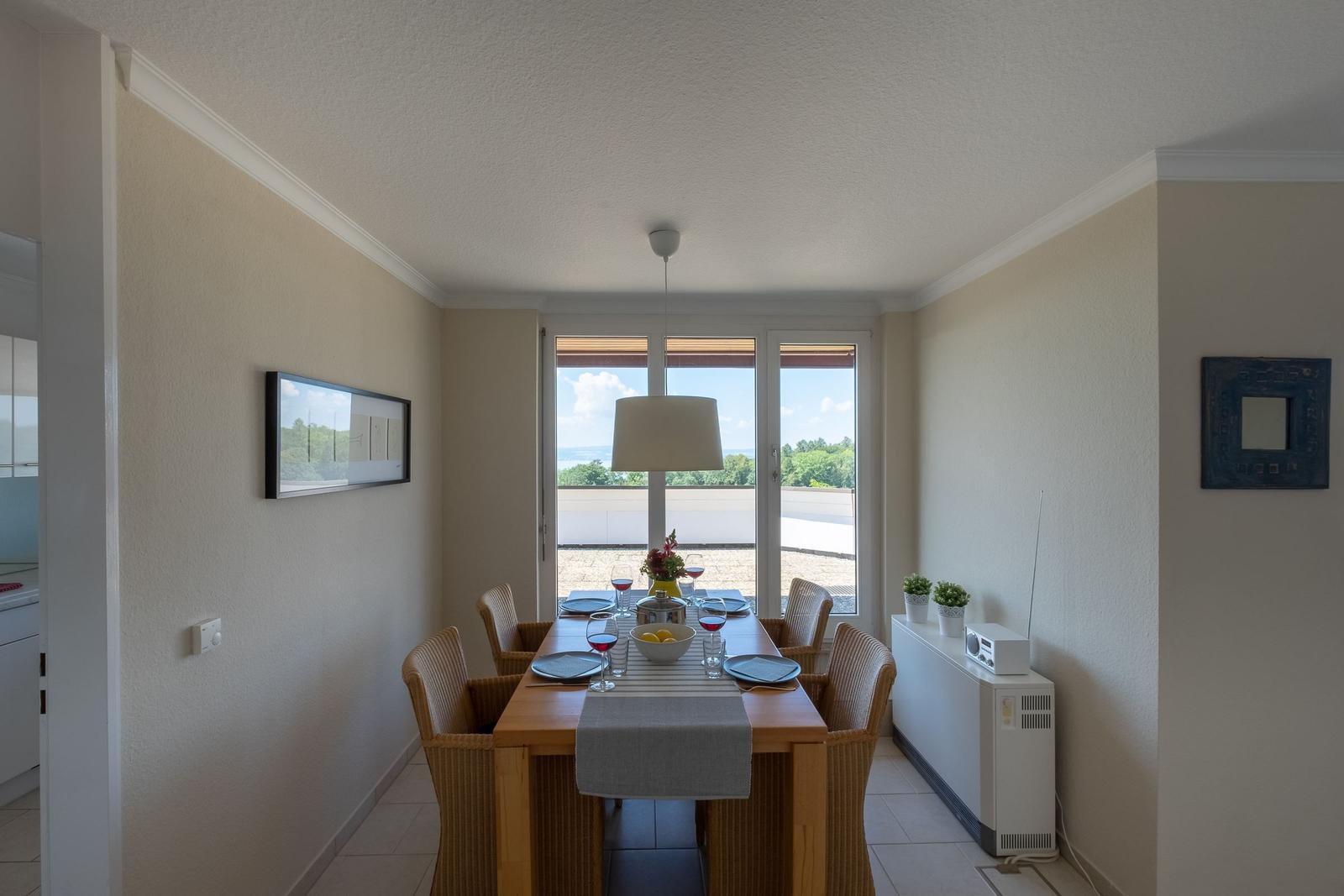 Esszimmer mit Tisch, Stühlen und Blick auf Balkon